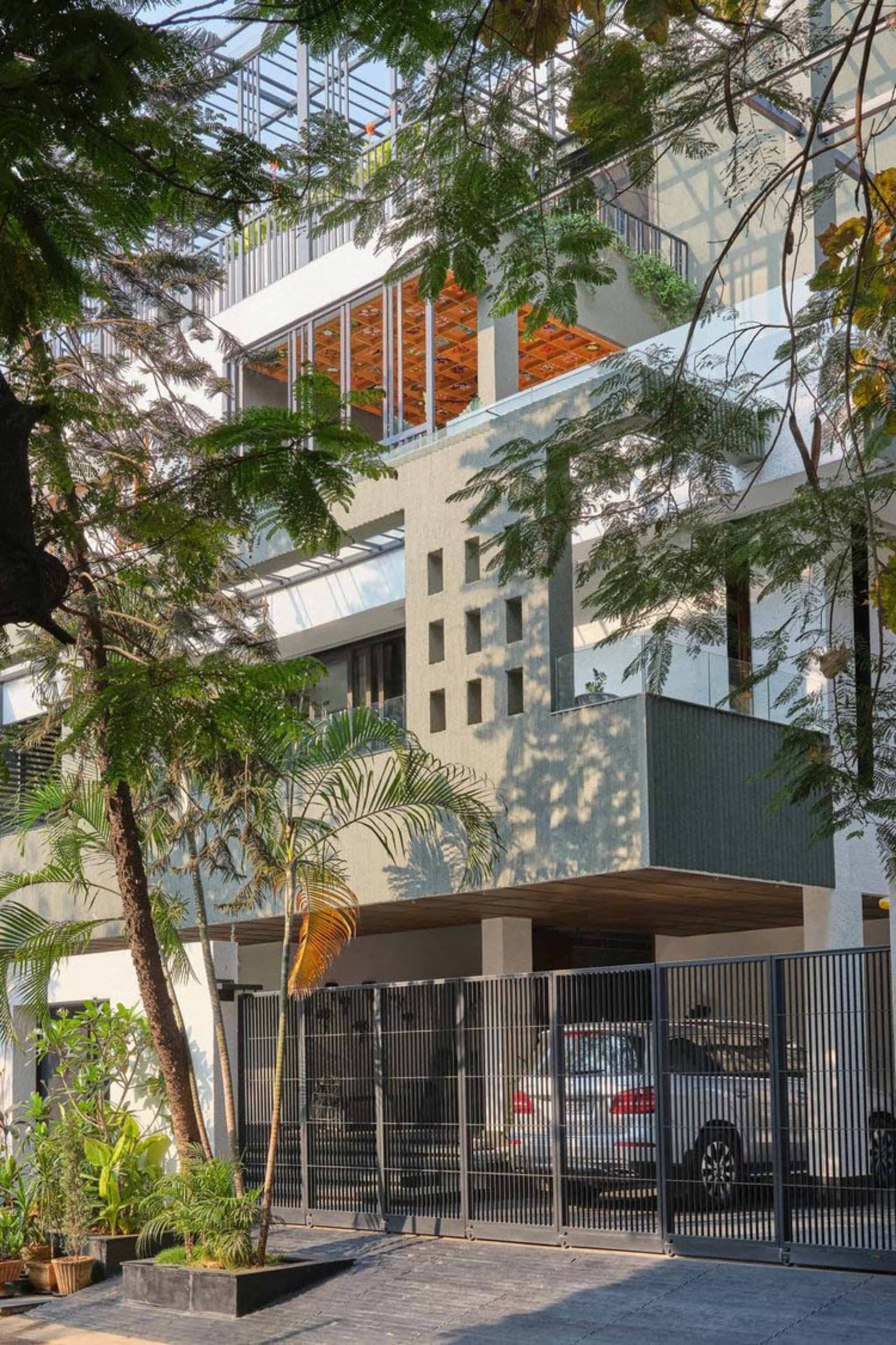 Modern residential building entrance featuring a concrete facade and metal gate.