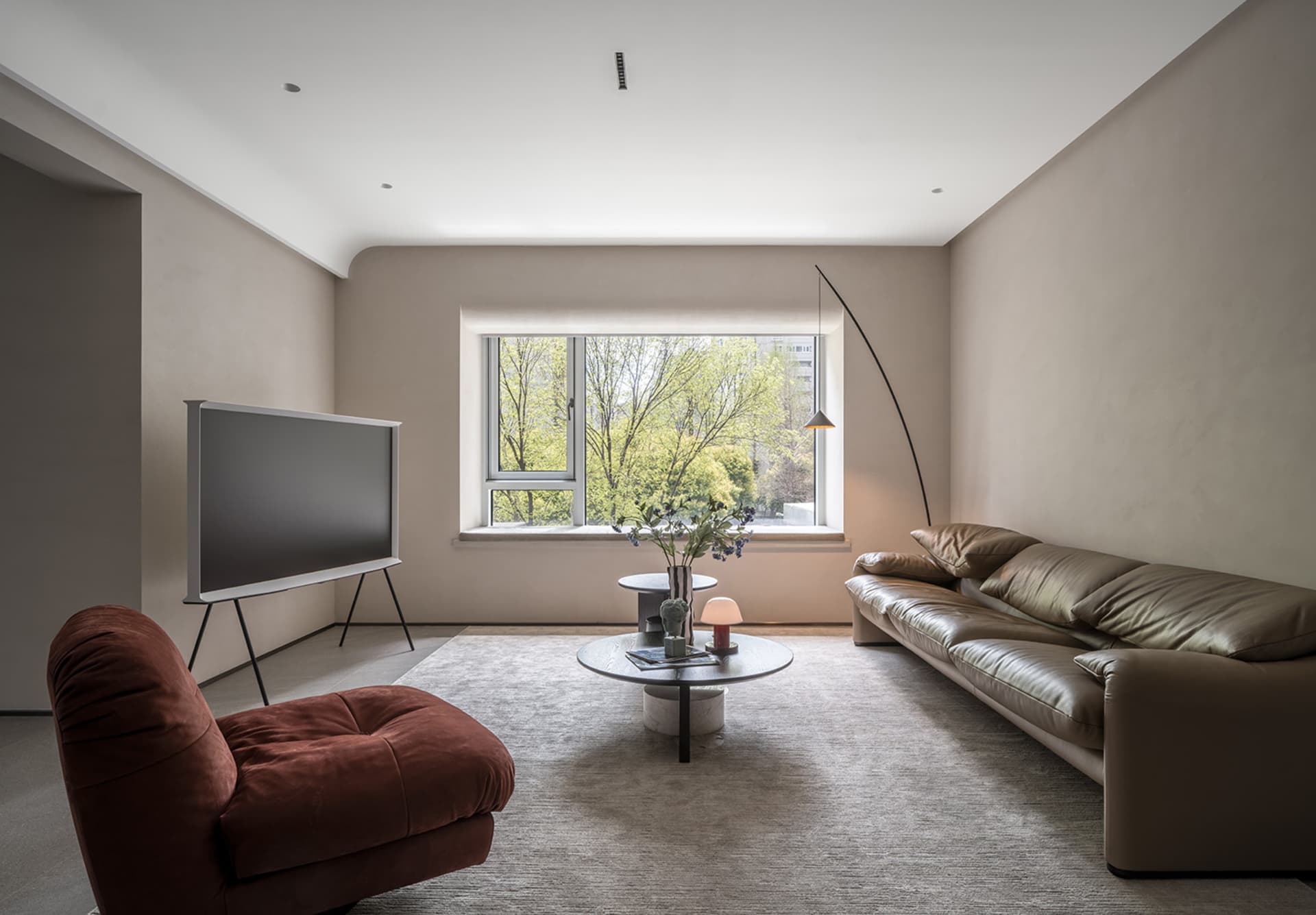 Contemporary minimalist living room with modern furniture and neutral color palette.