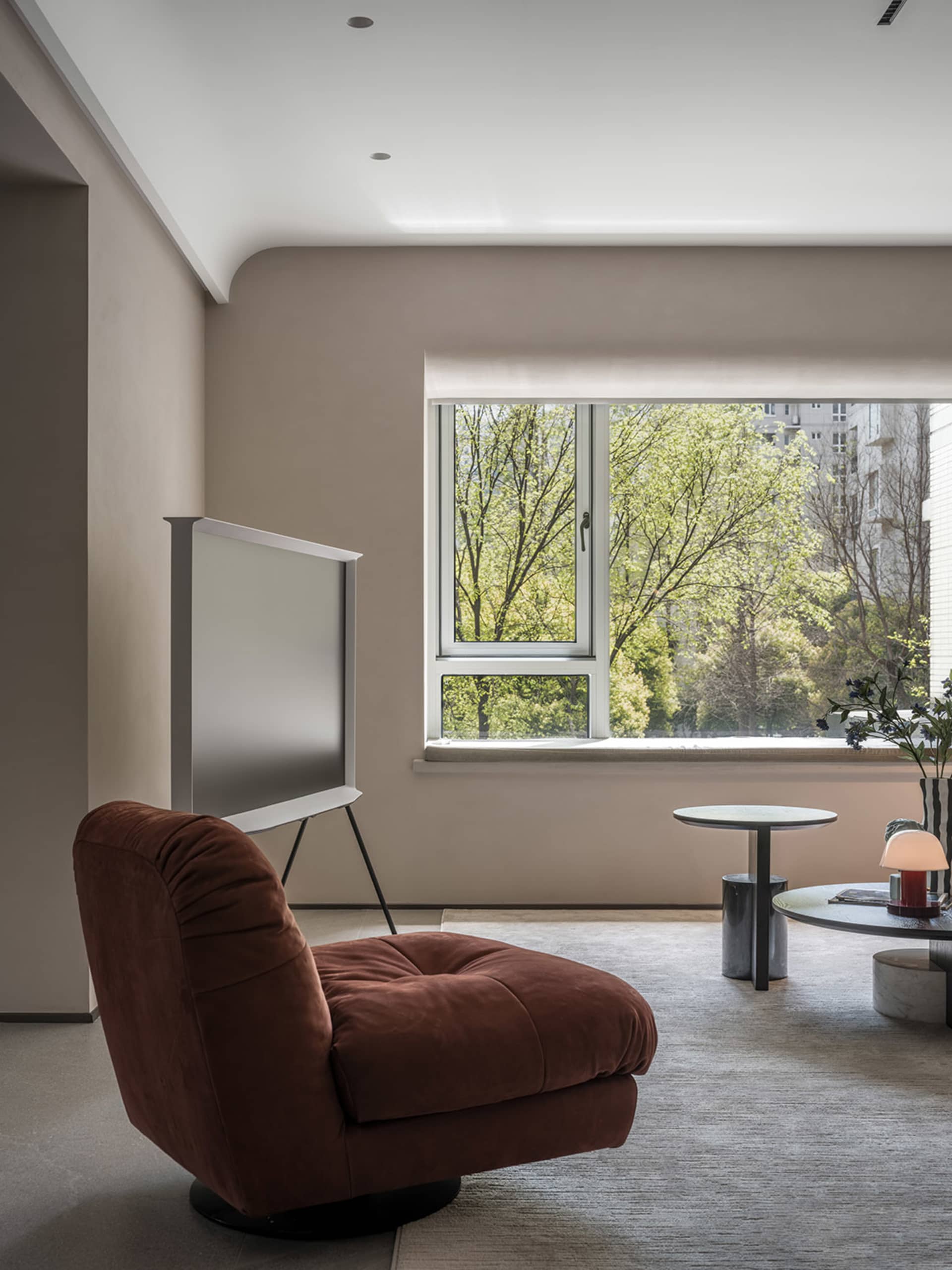 Modern living room featuring a purple upholstered chair and a white, flat-screen television.