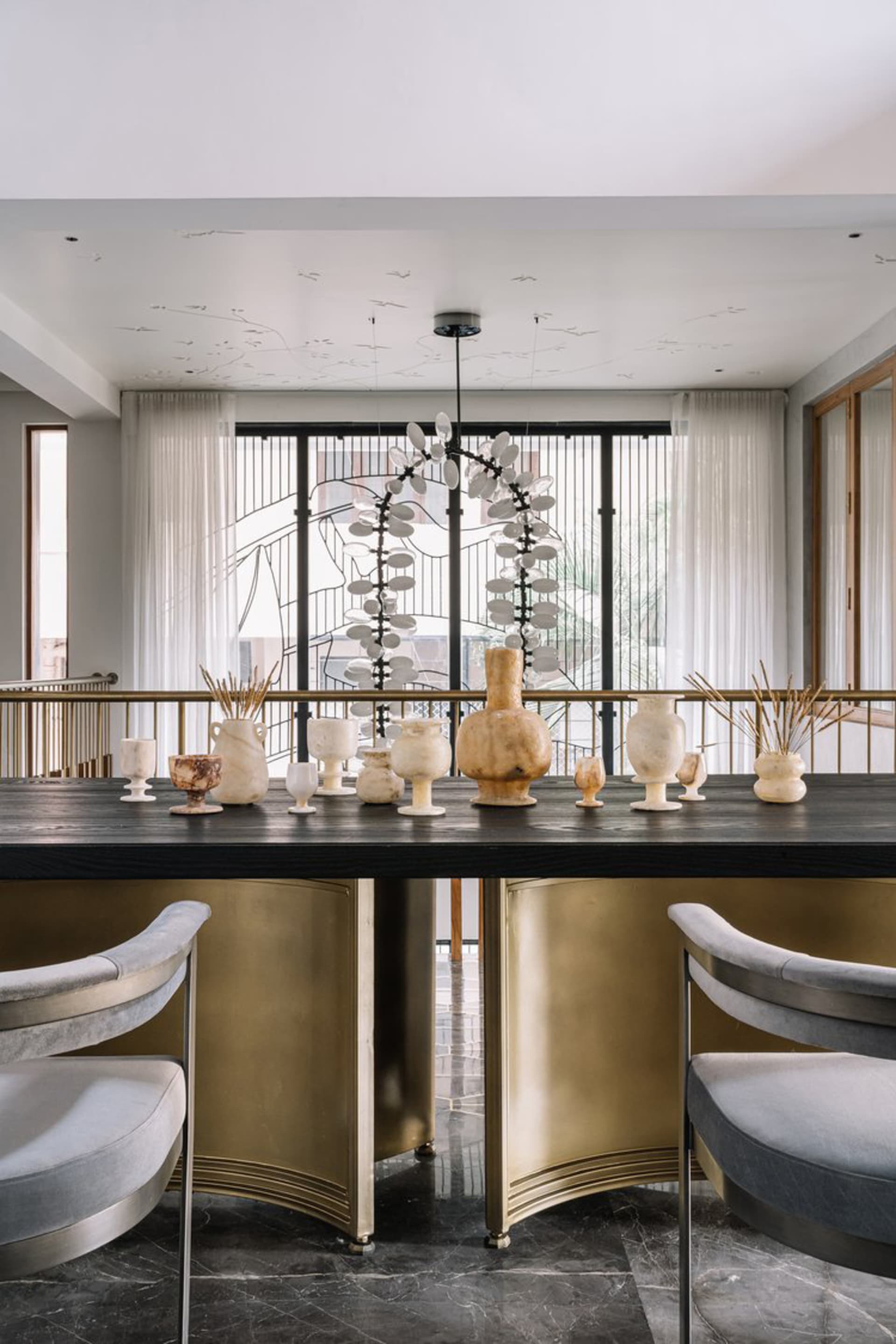 A modern dining room featuring marble tables and gold accents.