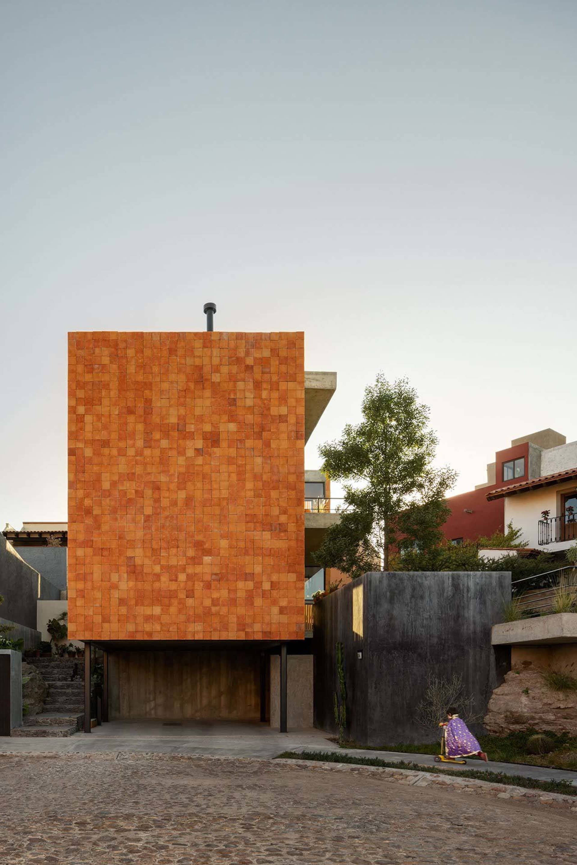 A modern residential building with a terracotta-tiled facade.
