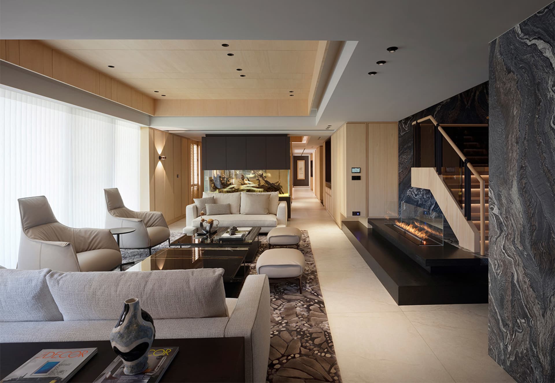 Photograph of a modern living room featuring a marble floor, a white sofa, and a stone fireplace.