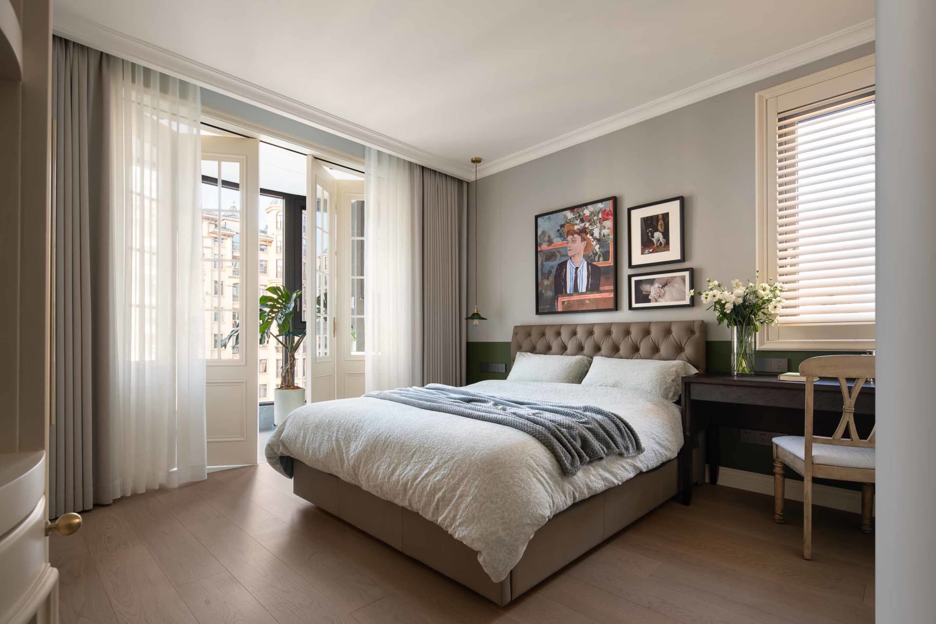 A minimalist bedroom featuring a comfortable bed, elegant furniture, and artistic wall decor, bathed in soft, natural light.