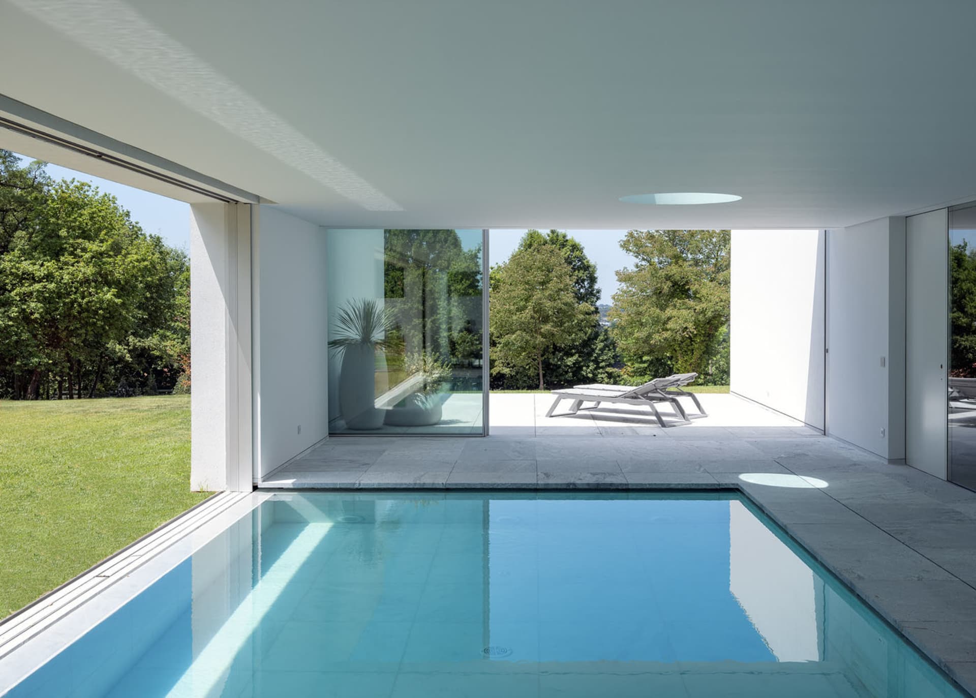 Modern interior design featuring a glass swimming pool.