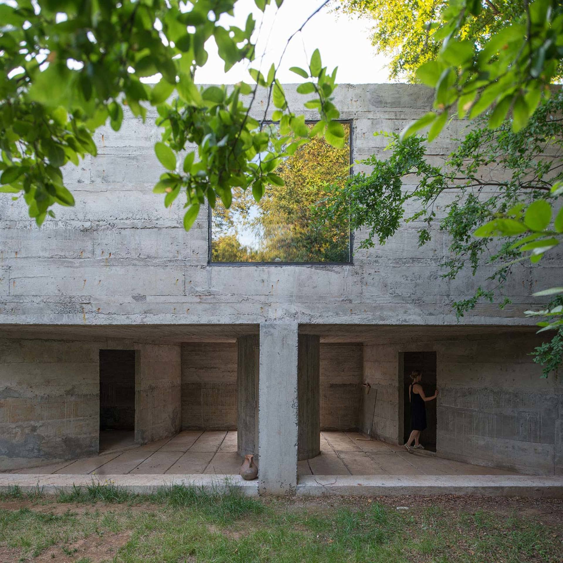 Concrete interior space with a large window and natural light.