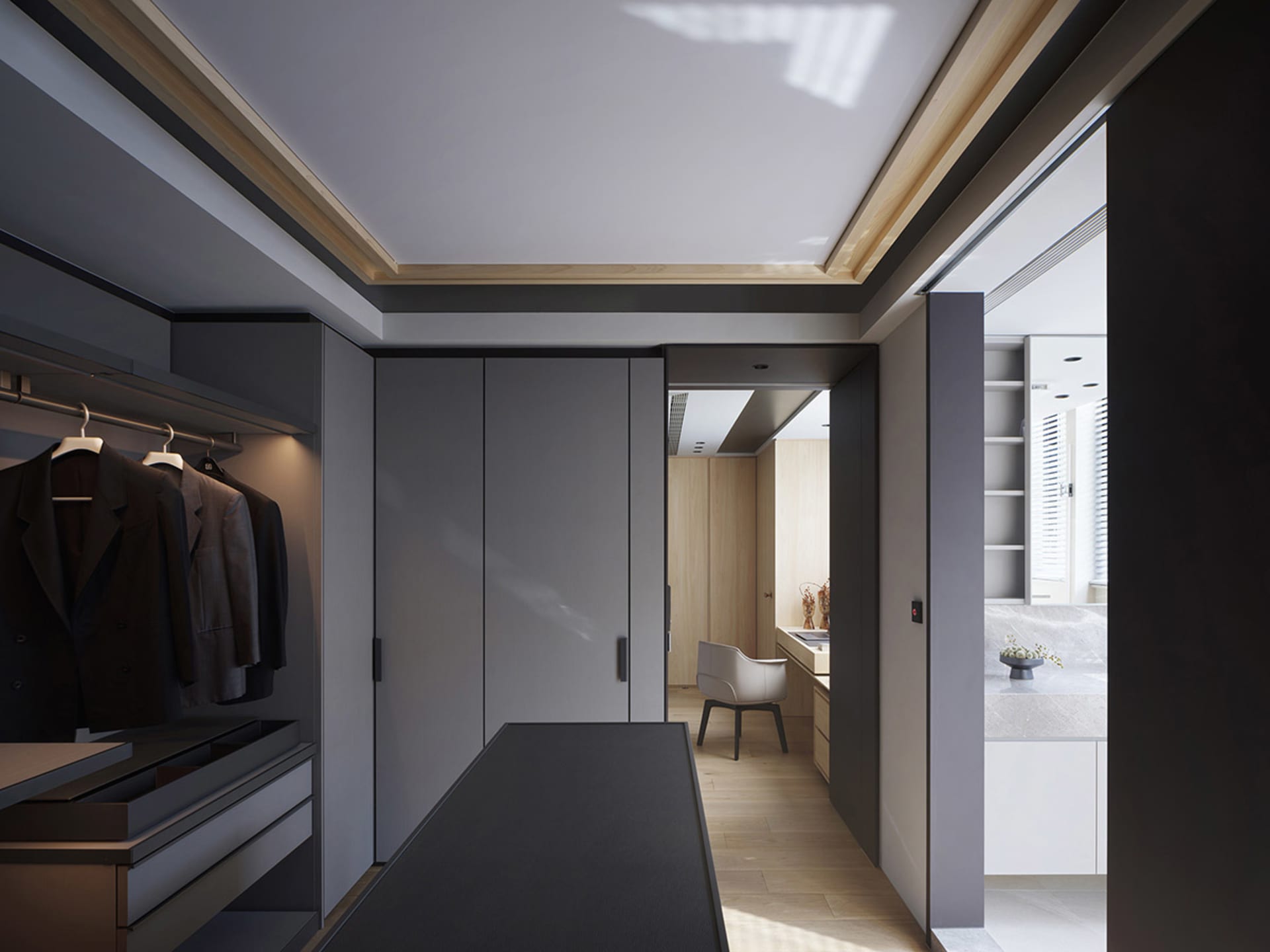 A modern closet with gray paneled walls, dark wood floors, and a minimalist design.