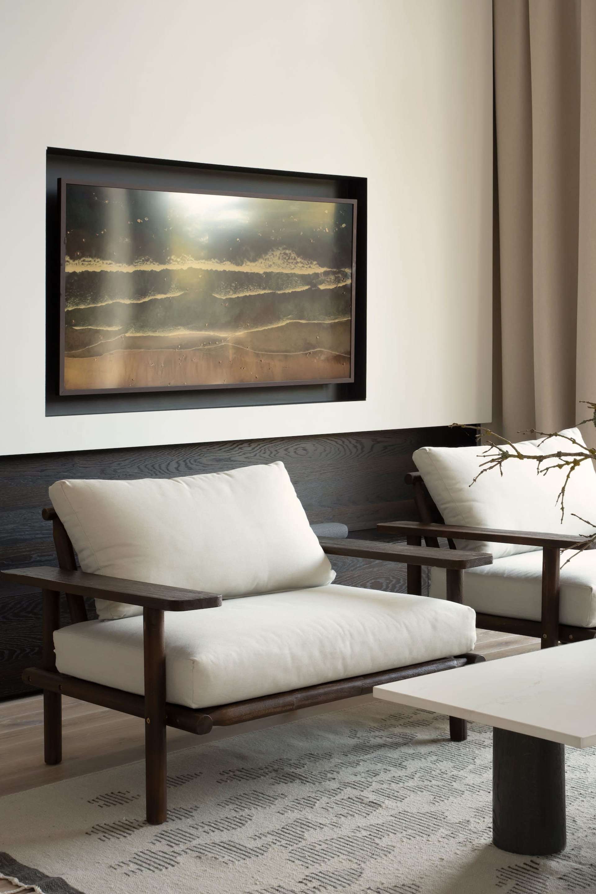 A minimalist living room with white furniture and wooden accents.