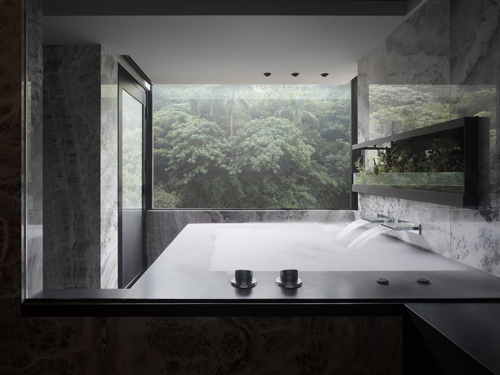 Modern minimalist bathroom with marble fixtures, large window overlooking greenery, and water feature.