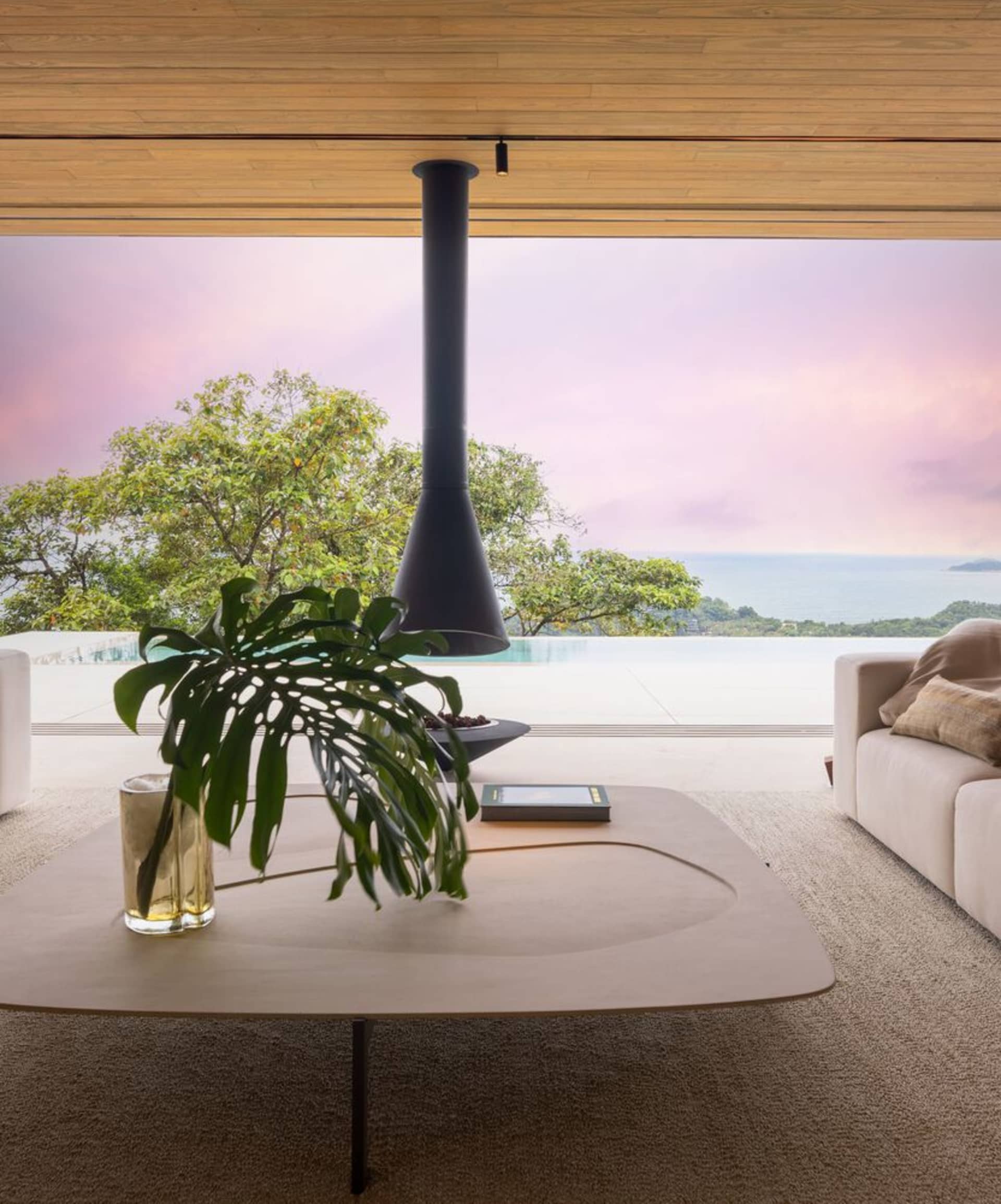 Modern living room with large glass windows and a wood floor.