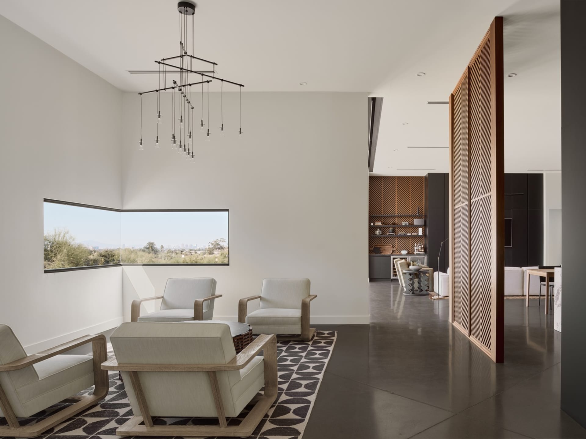 A modern living room with white furniture and concrete floors.