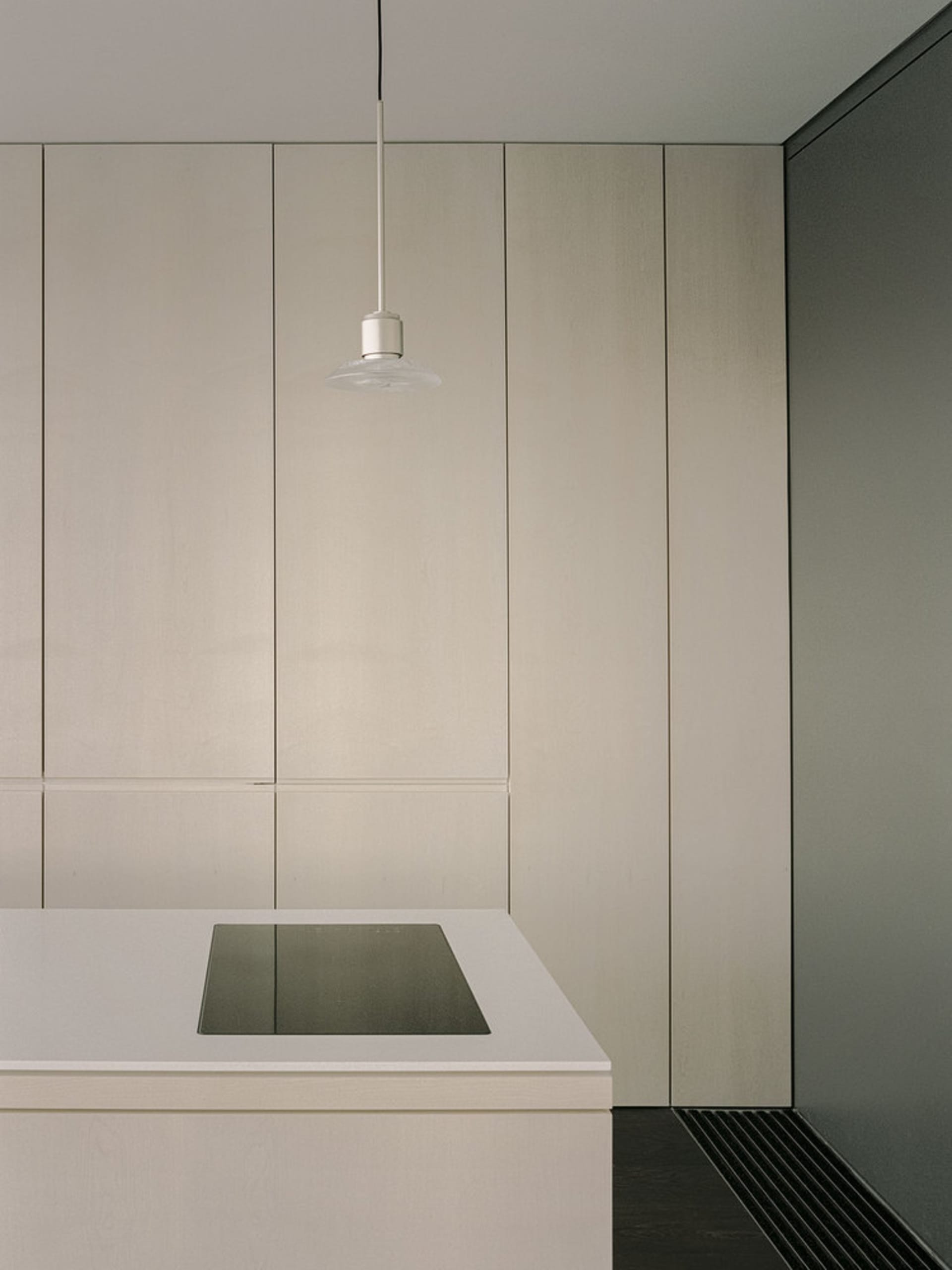 A minimalist kitchen with white cabinets and a sleek, modern design.