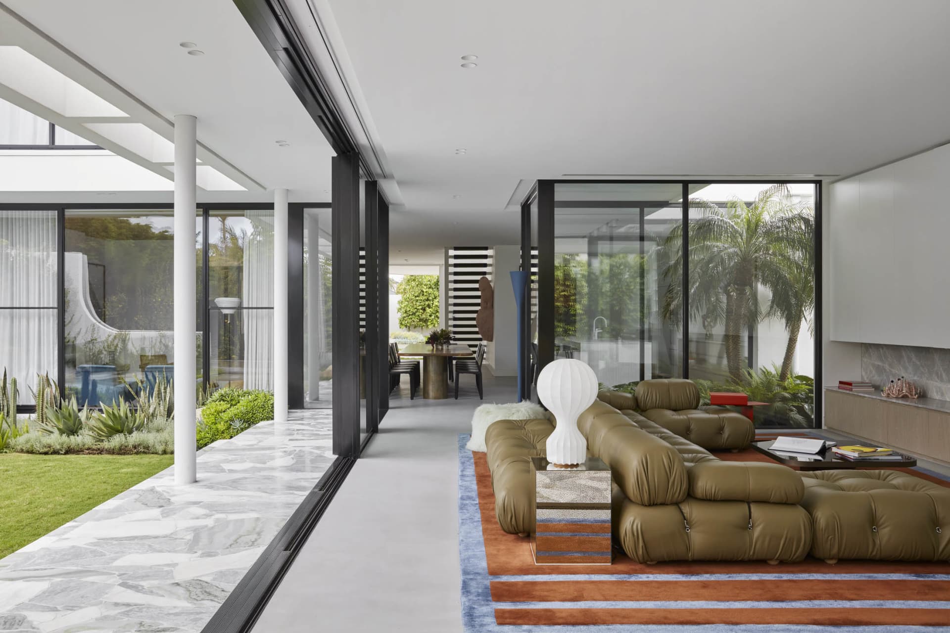 Well-lit, modern living room with a leather couch.