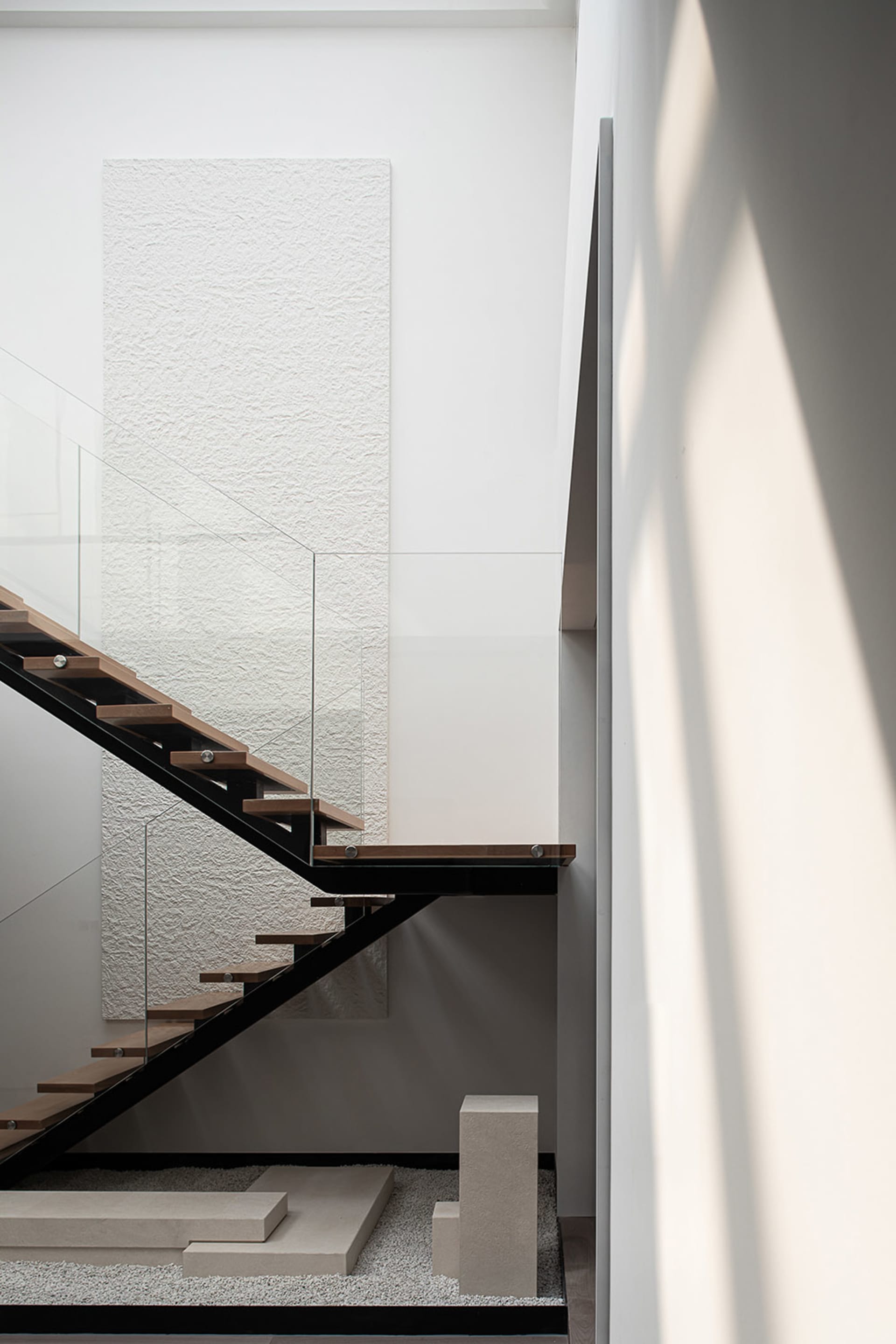 A modern staircase with black metal rails and wooden steps.