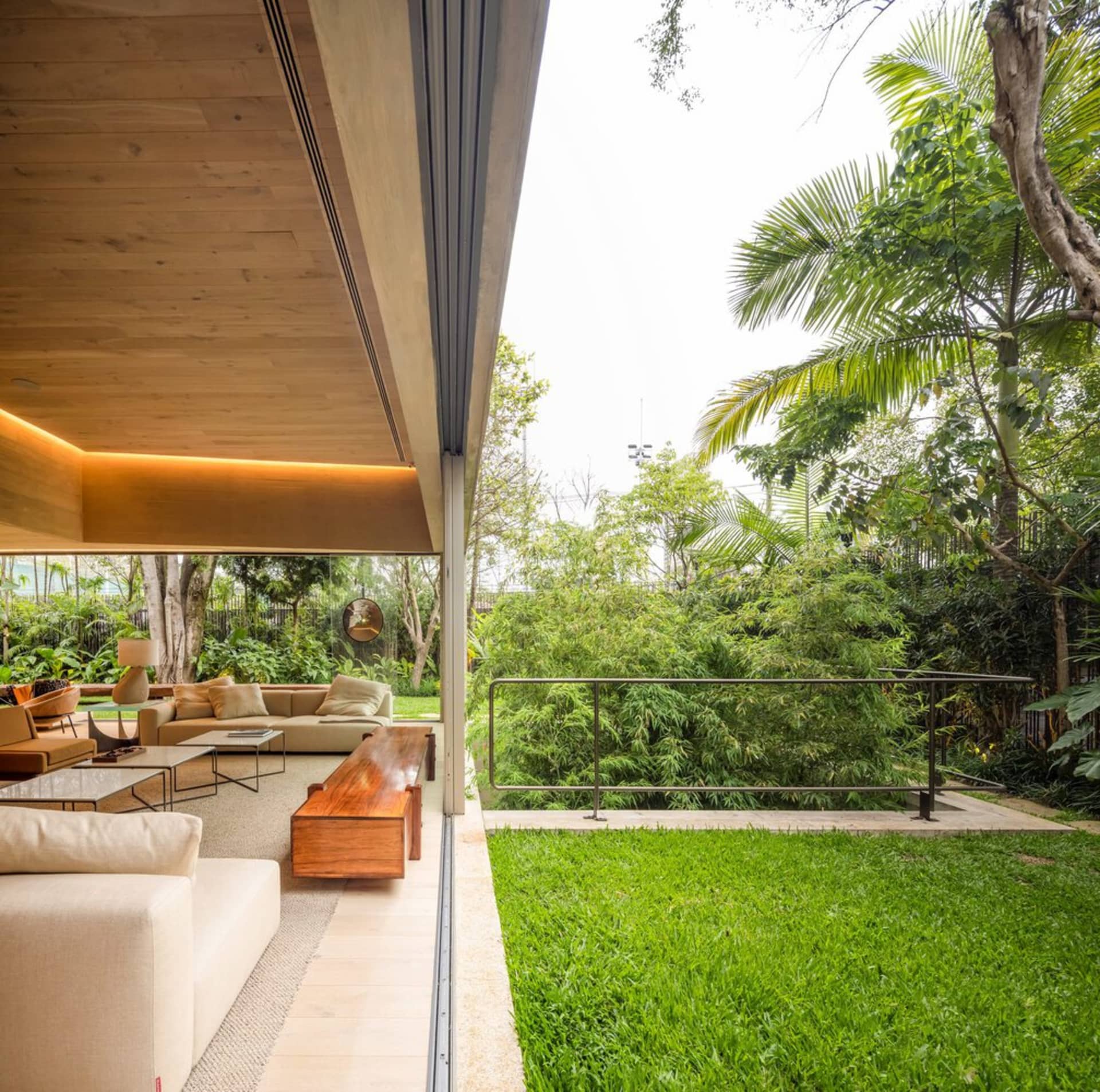 Modern living room with outdoor view, featuring a combination of wooden and concrete materials.