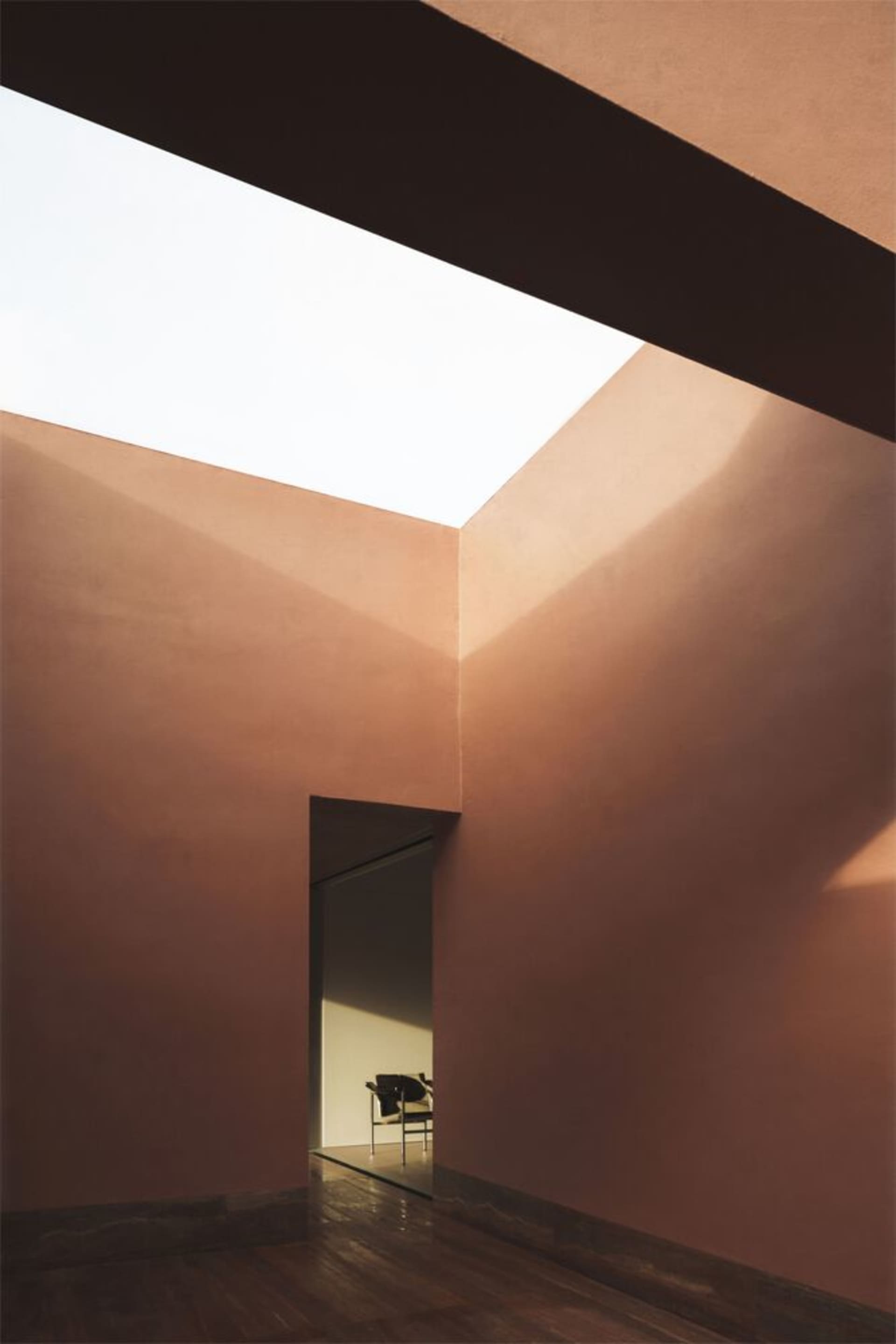 A minimalist space featuring concrete walls and glass ceiling.