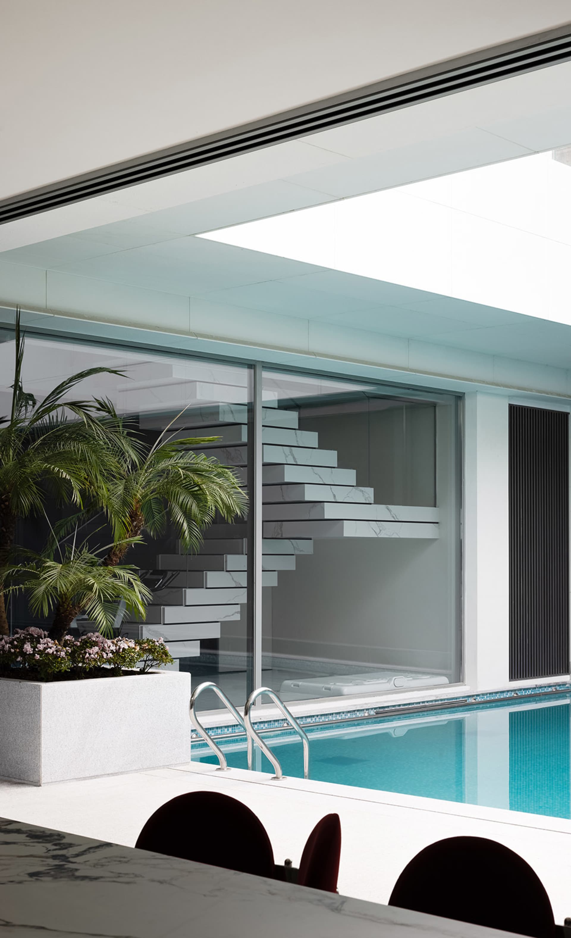 Modern swimming pool interior with marble and glass elements.