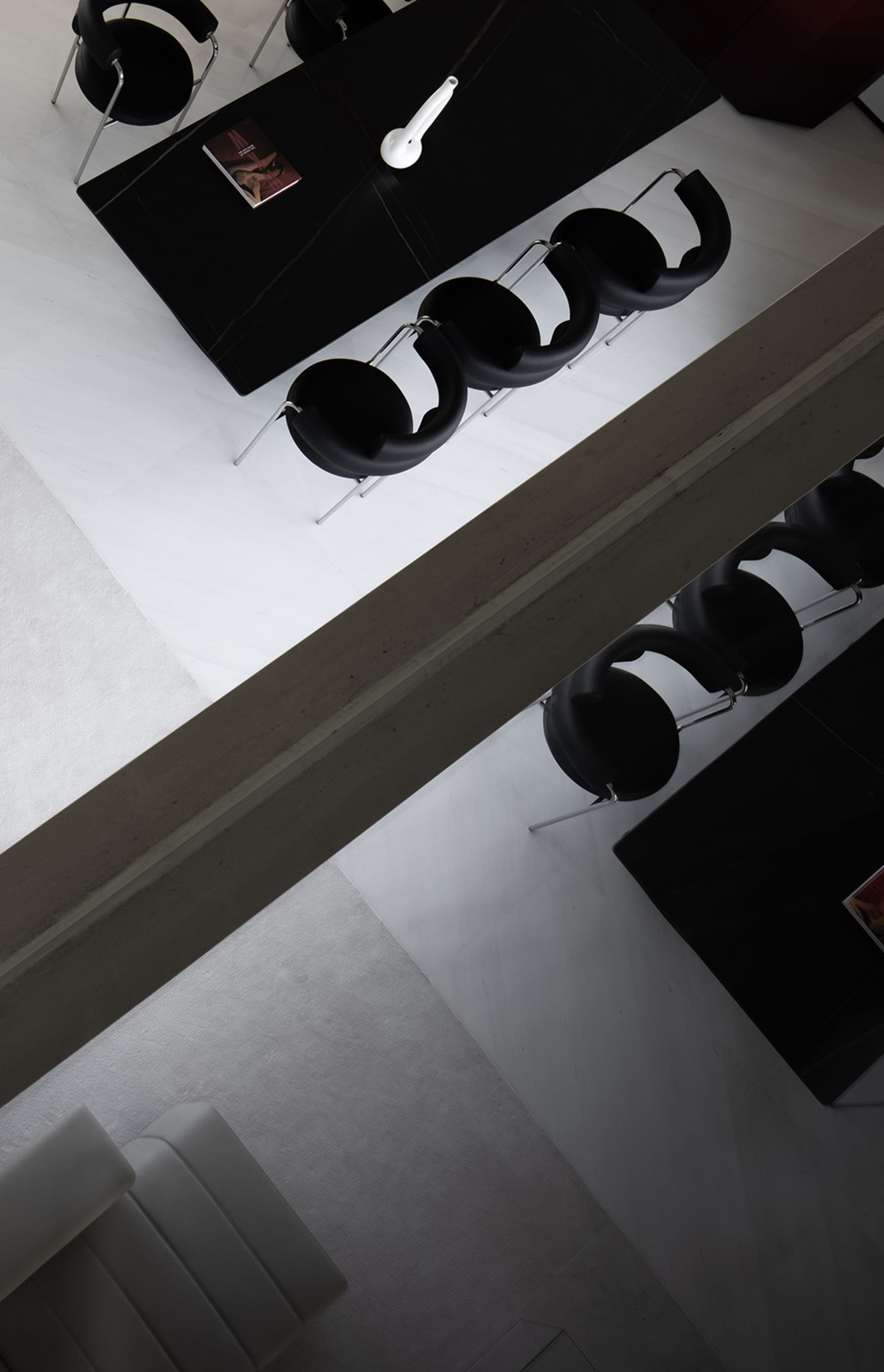 A minimalist dining room features modern black furniture and a sleek table.