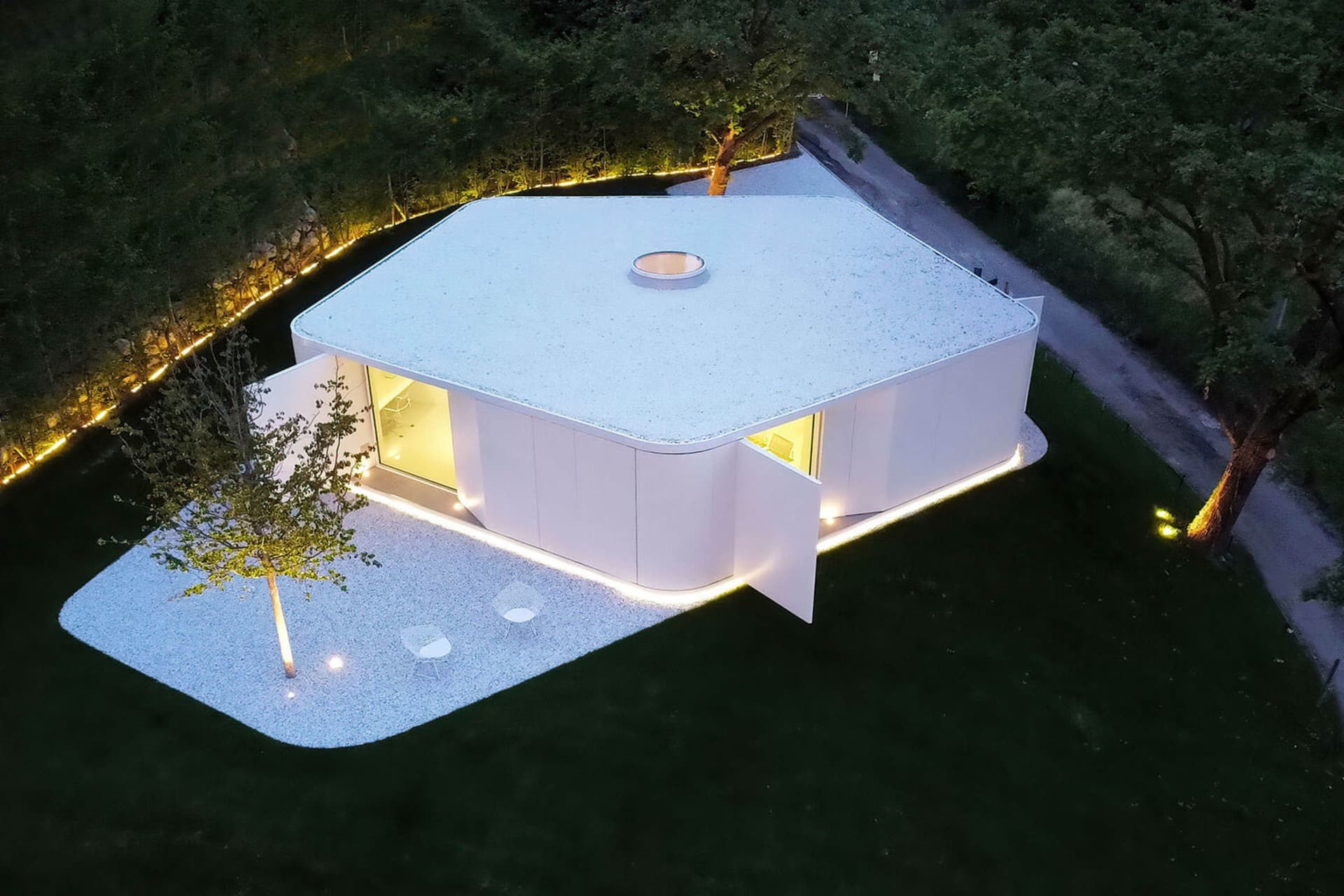 現代極簡住宅擁有白色混凝土外牆,搭配大面窗與極簡室內設計。