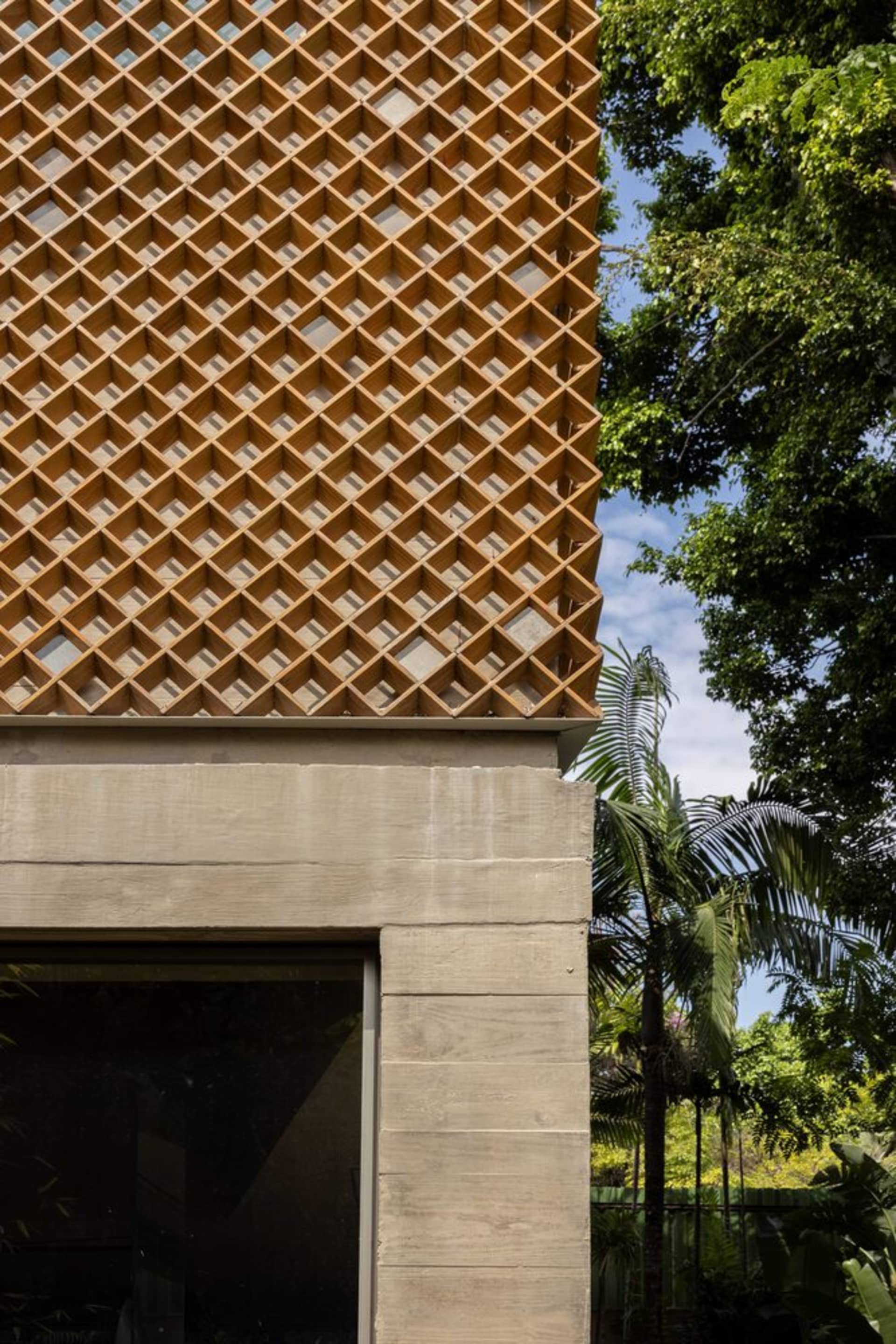 Modern building exterior featuring a wooden lattice design for ventilation and aesthetic appeal.