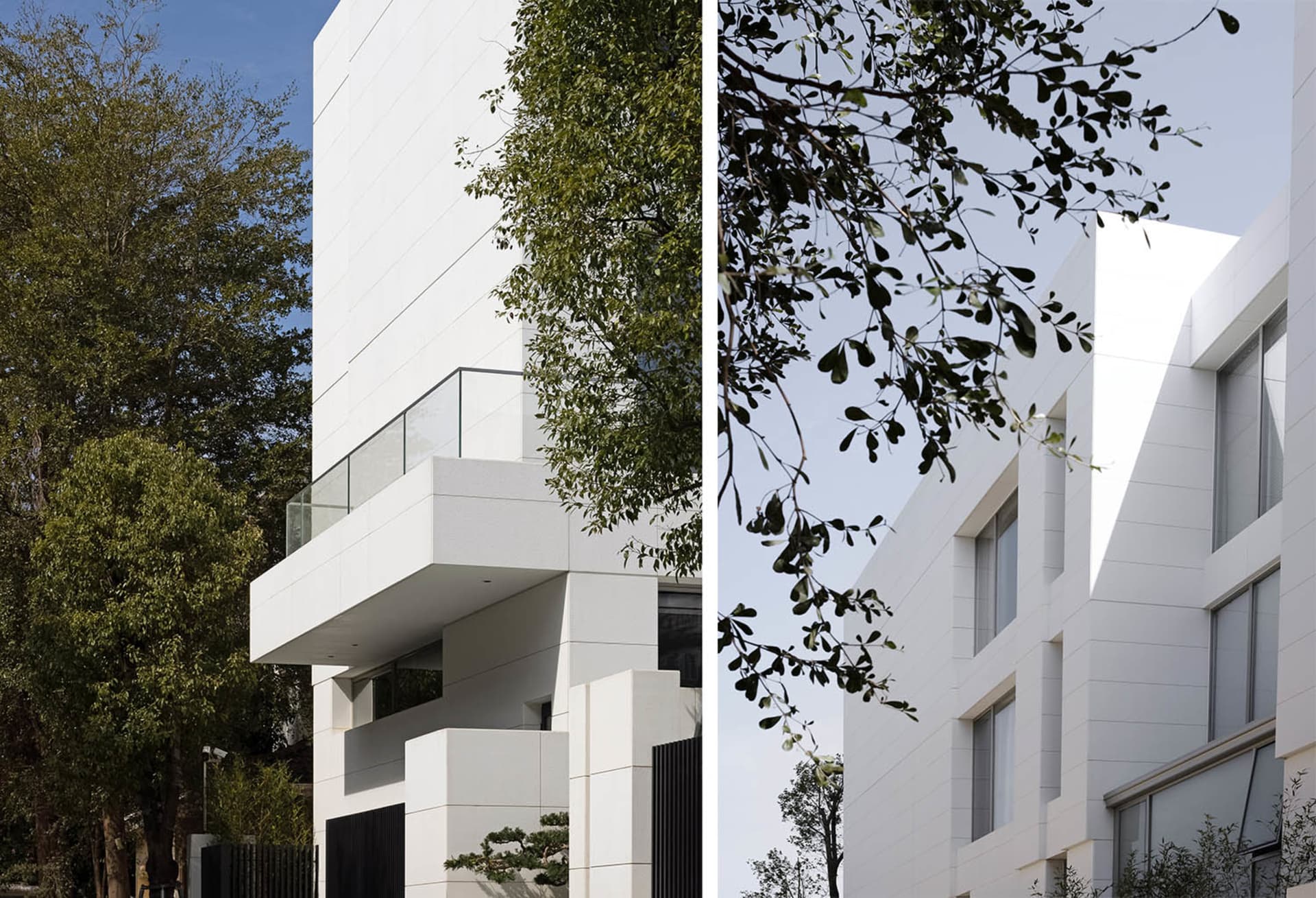 Contemporary residential building with white stone and glass exterior.