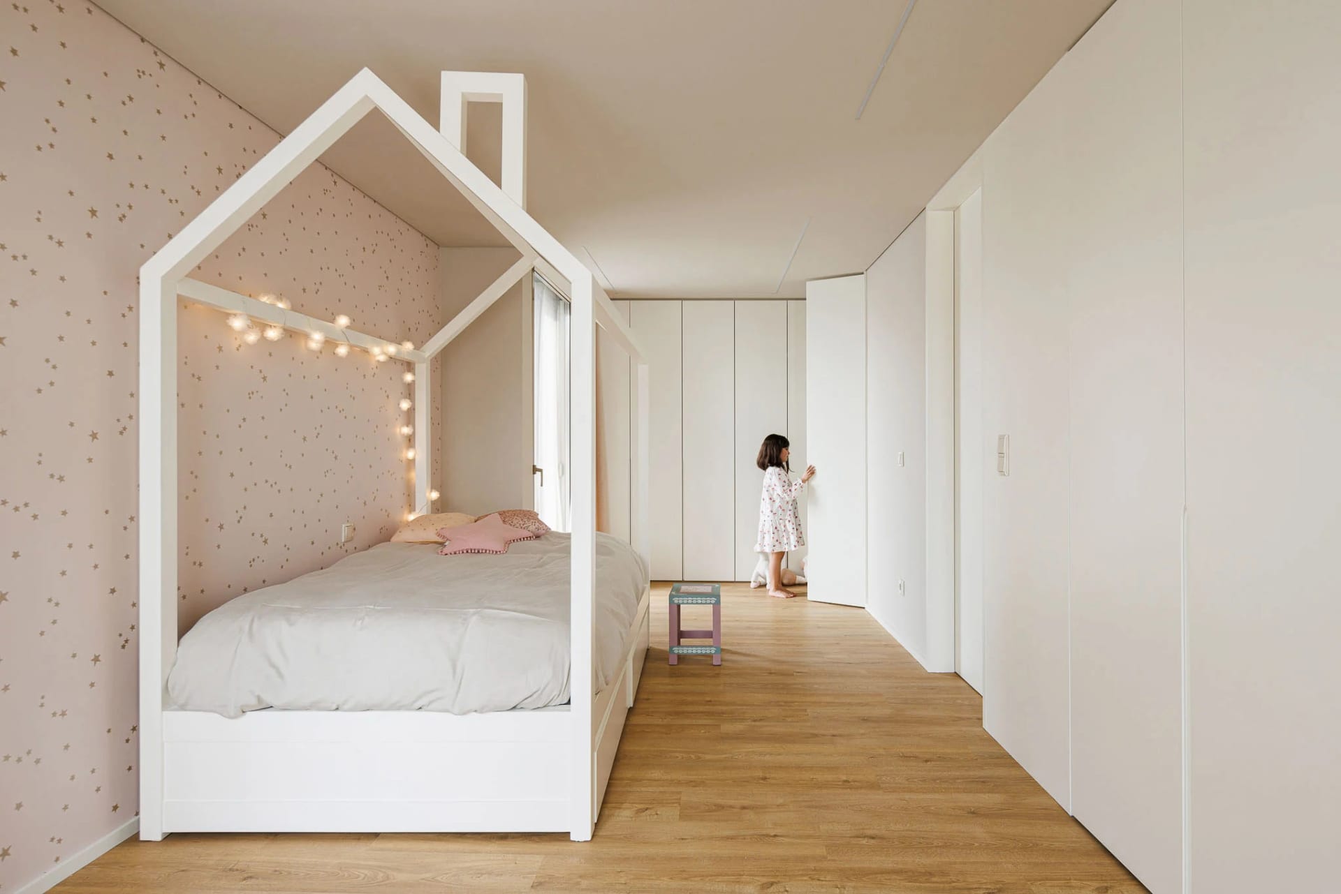 現代兒童臥室，配有小屋造型床架、木地板與柔軟織品。