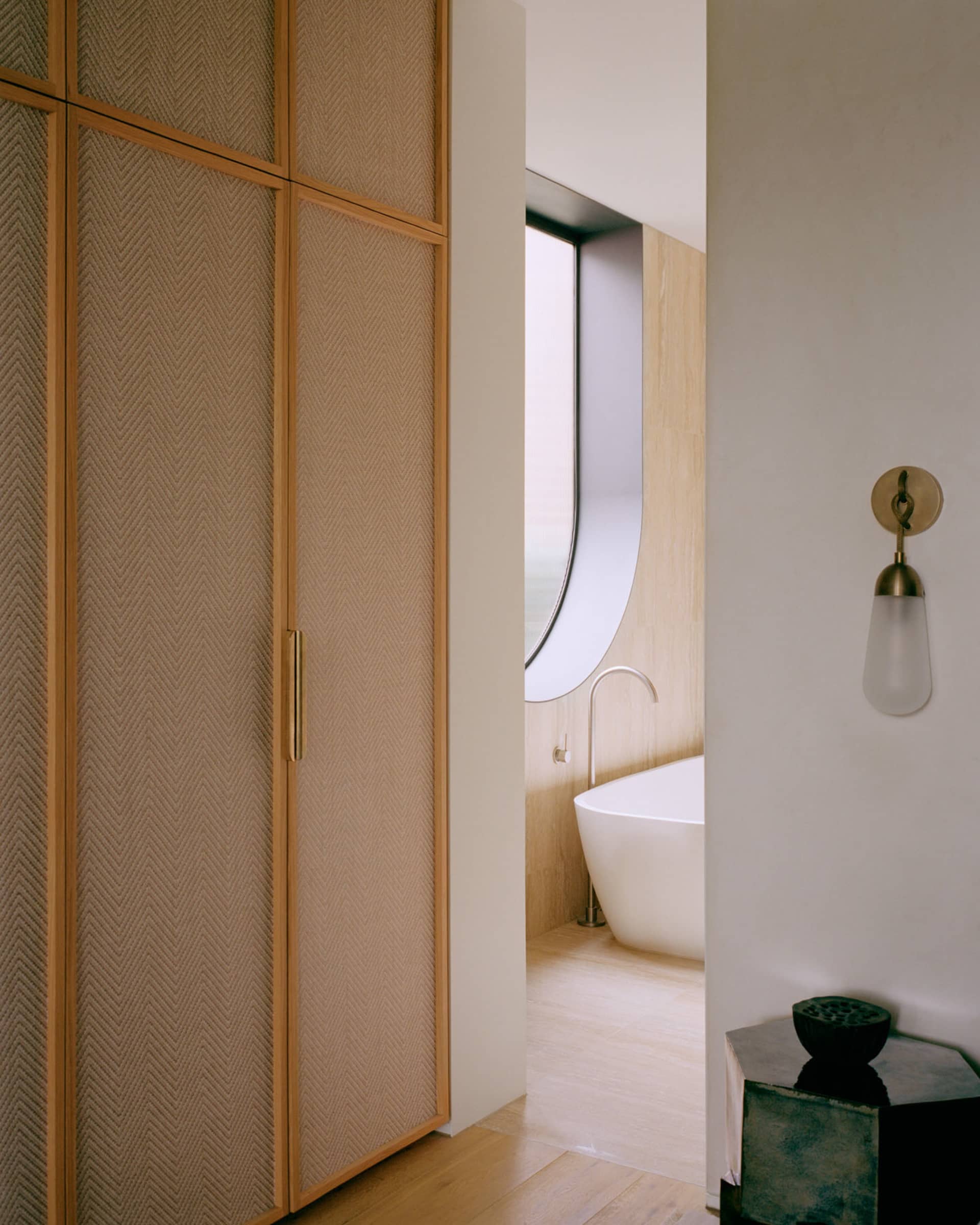 A minimalist bathroom with wooden paneling and concrete tiles.