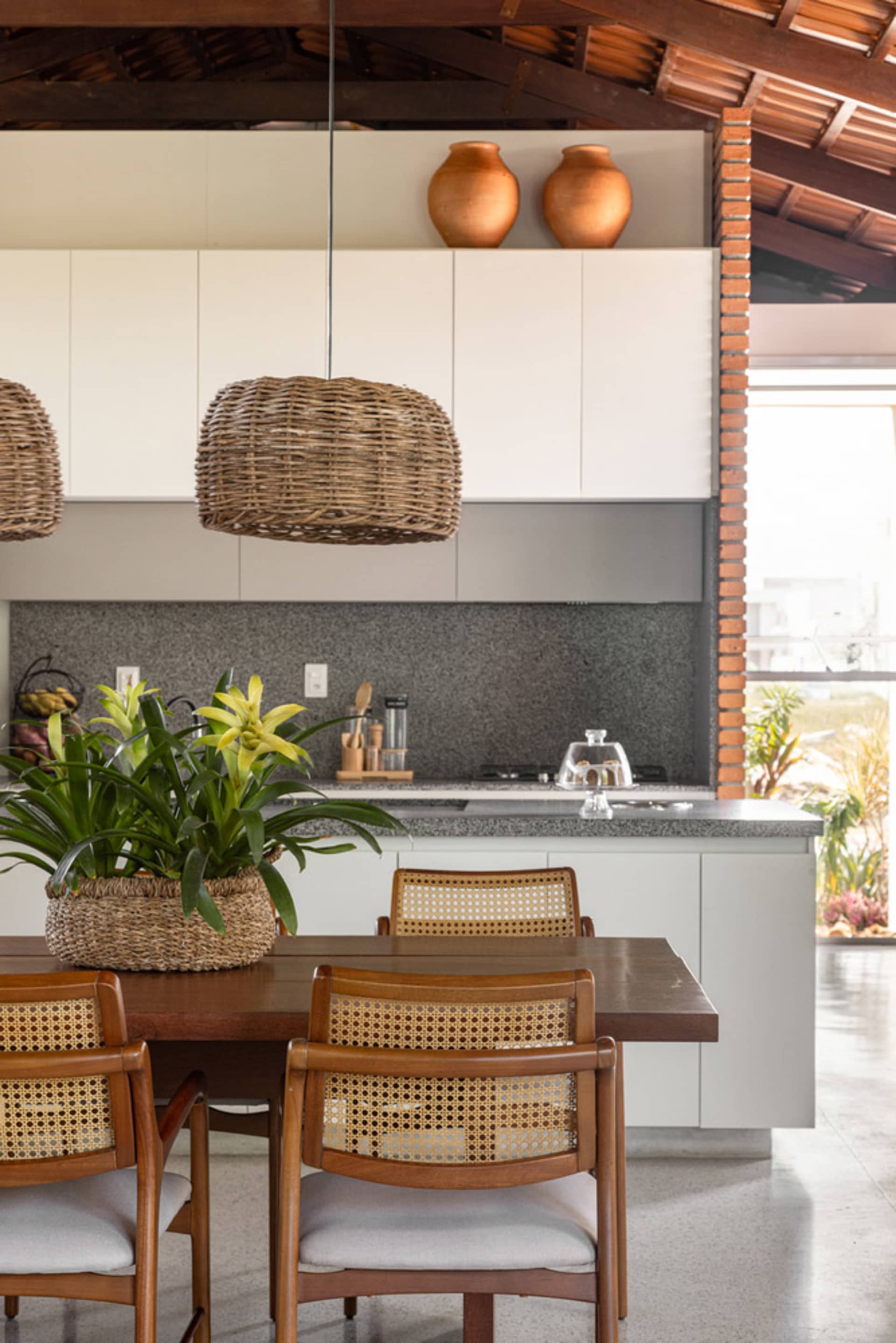 Minimalist residential kitchen featuring natural fiber pendant lights and bamboo wood accents.