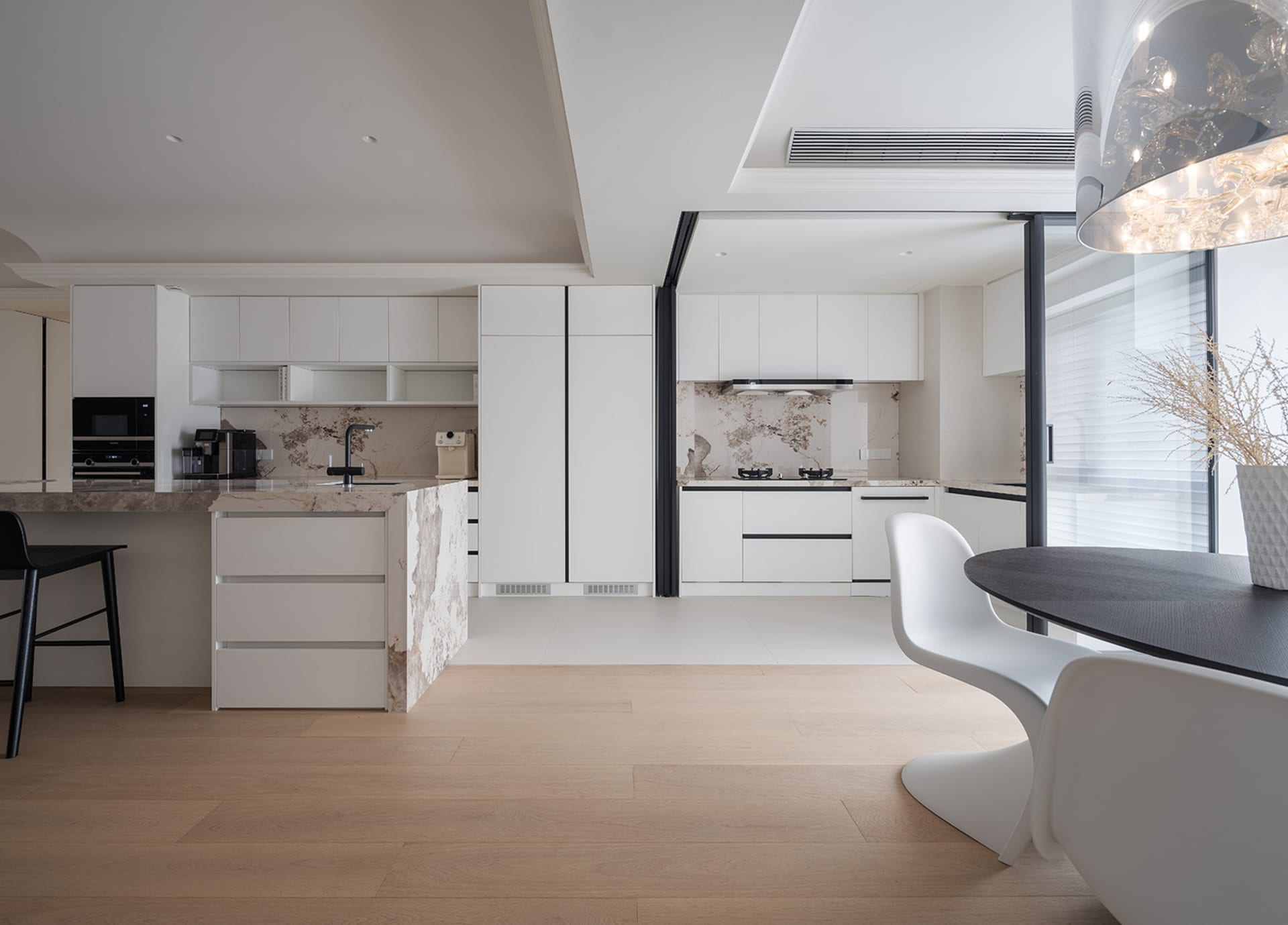 Modern white kitchen with marble countertops and white laminate cabinets