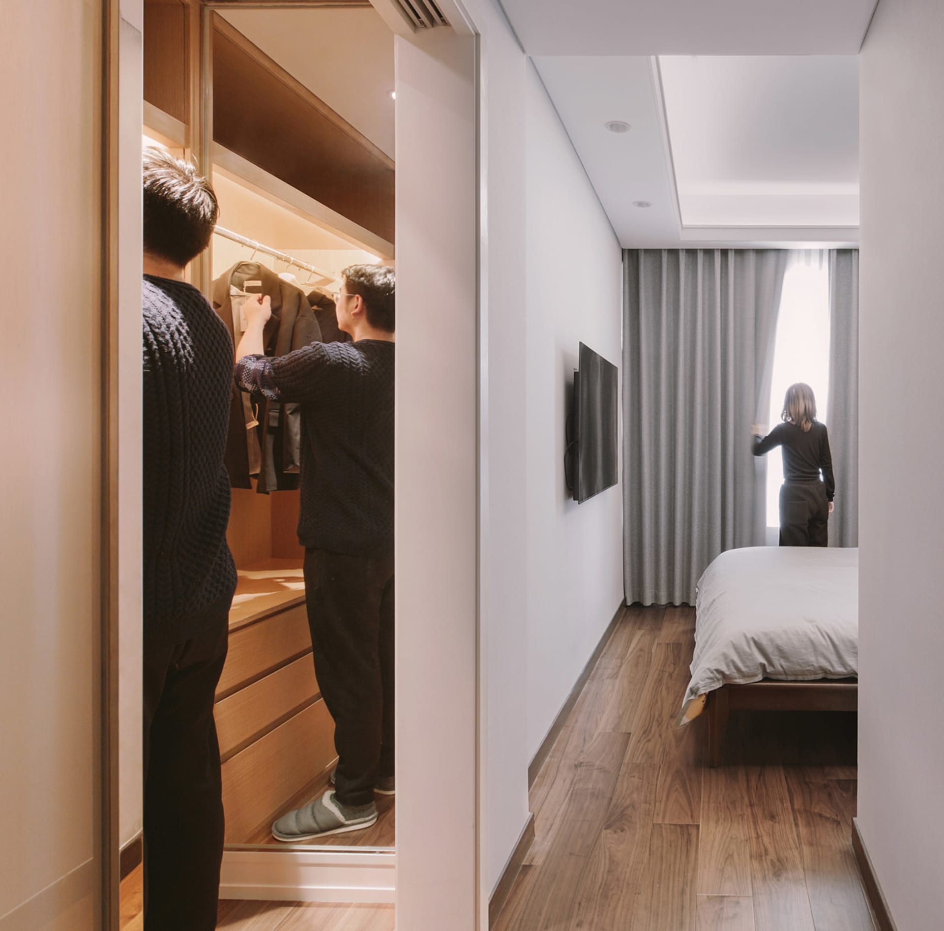 A modern bedroom with wood flooring, fabric curtains, and metallic furniture.