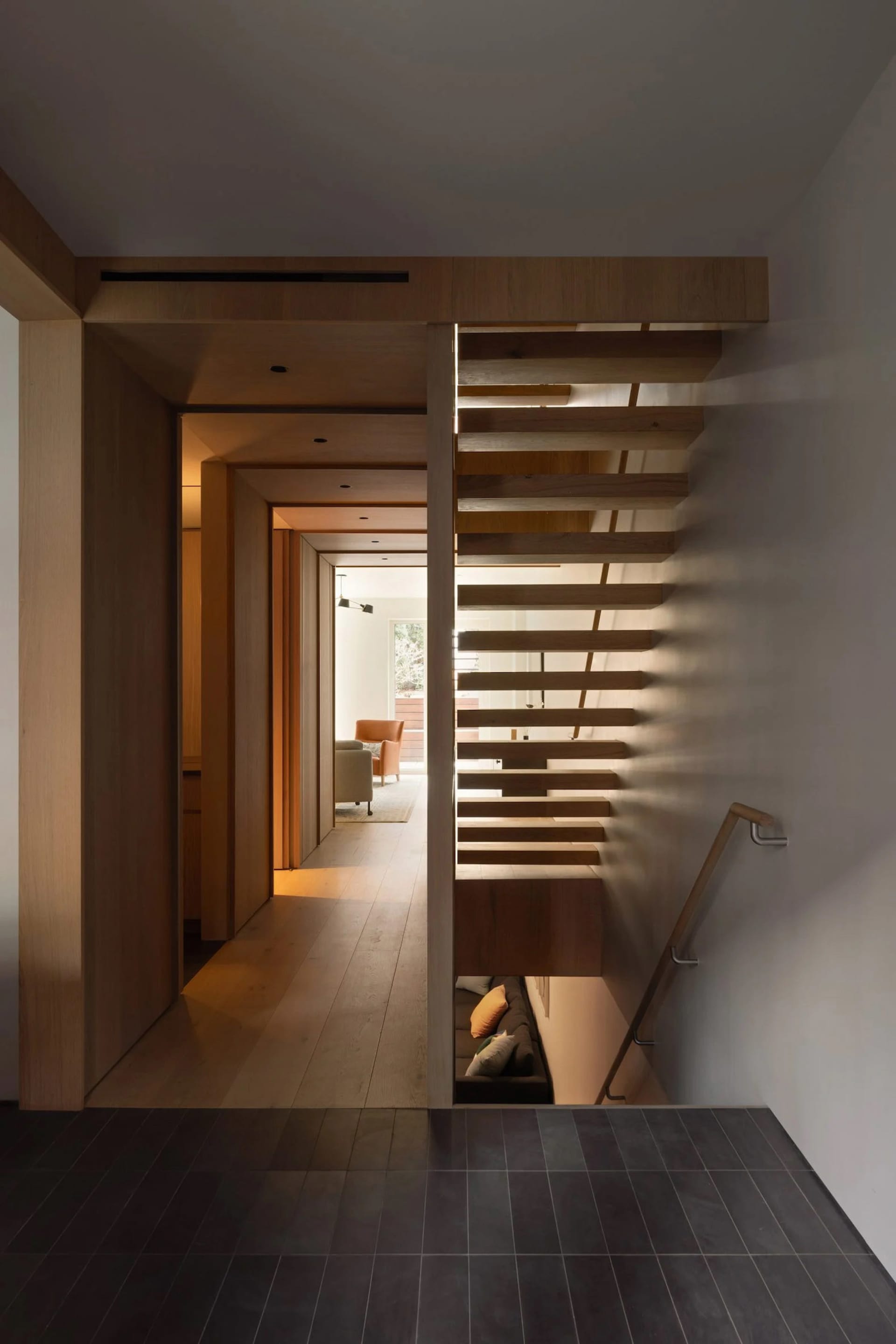 Modern staircase featuring warm, ambient lighting designed with wooden elements.