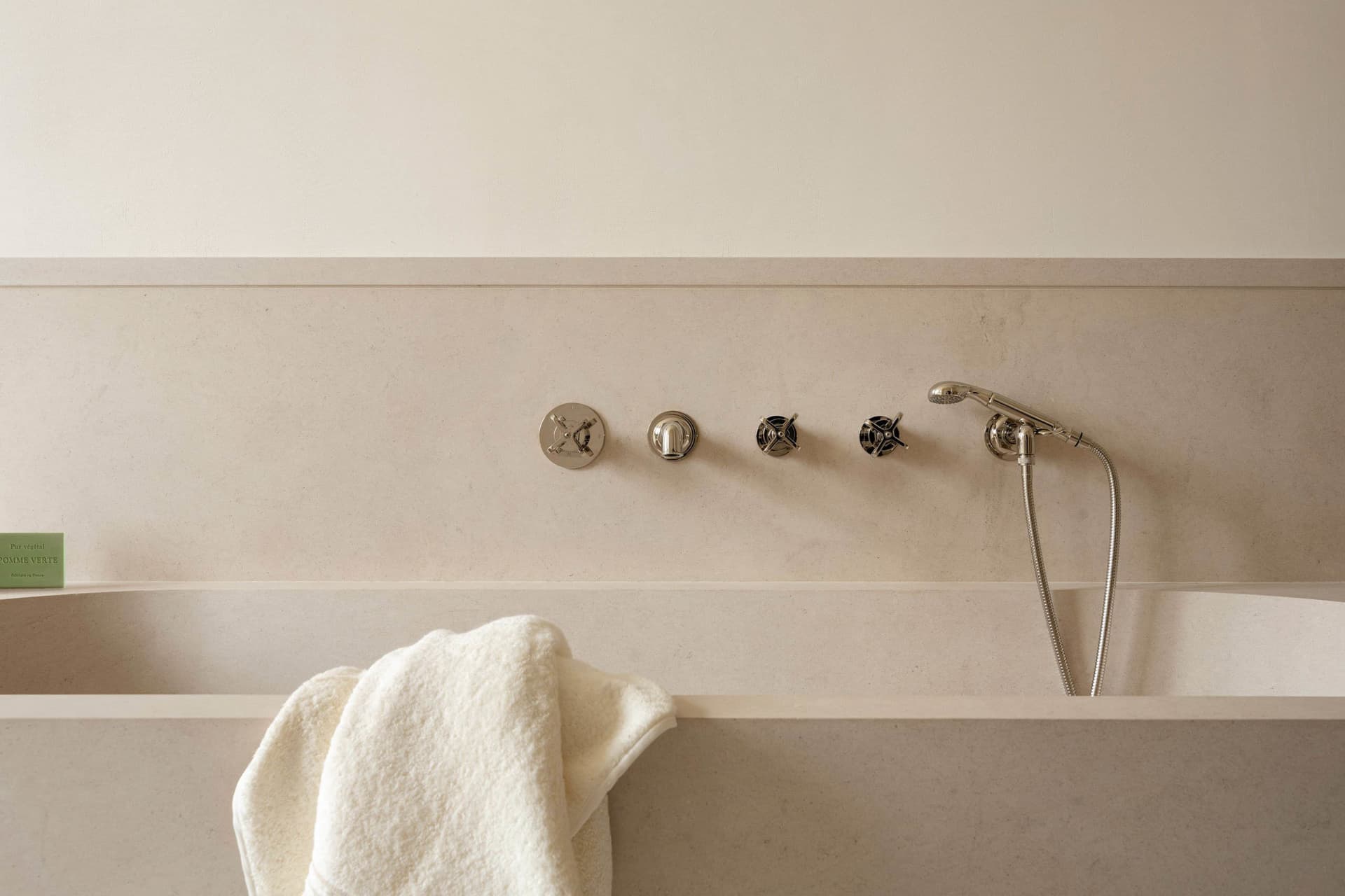 Modern bathroom with a minimalist design featuring a concrete bathtub and sleek, chrome fixtures.