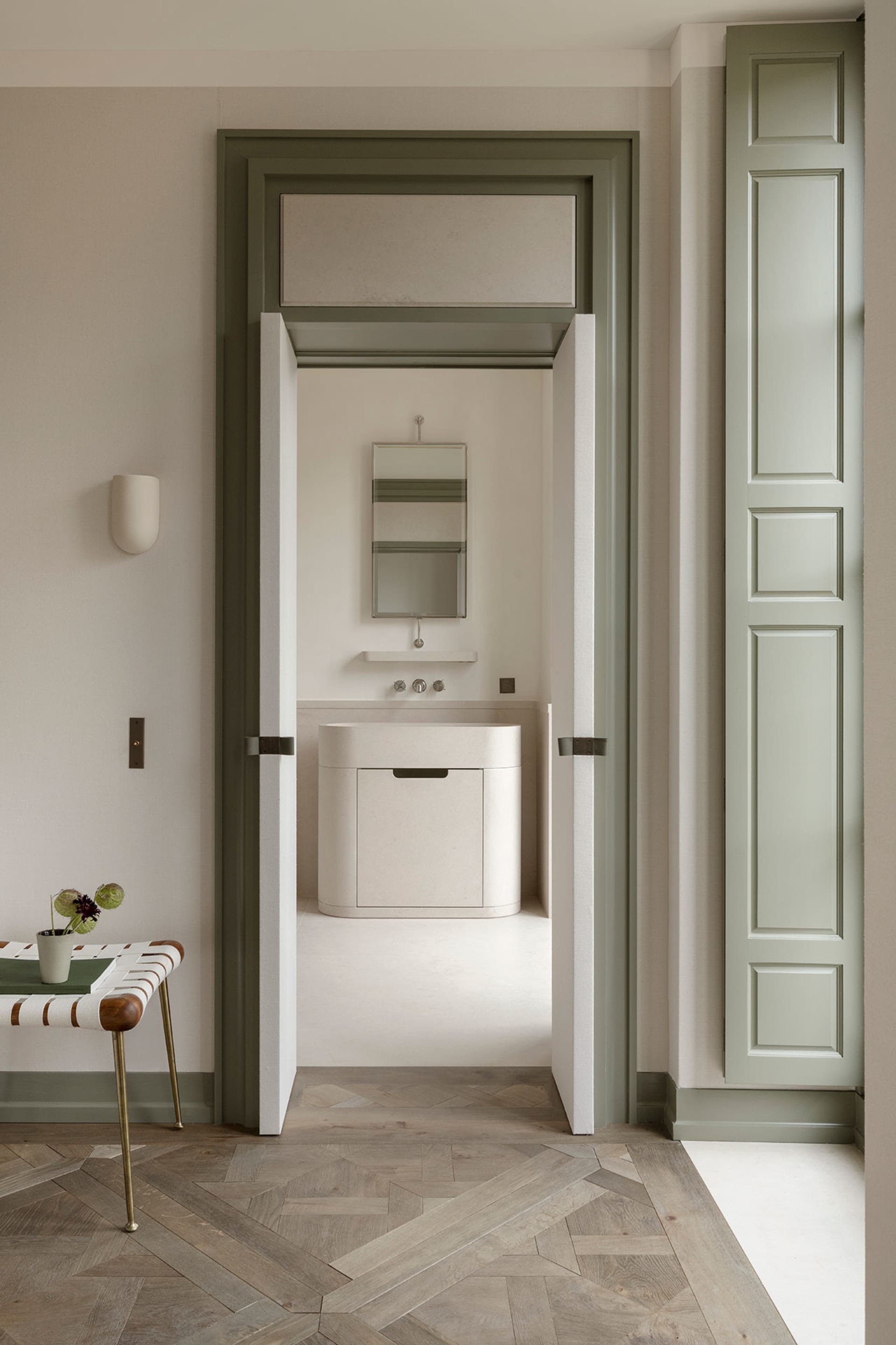 Modern bathroom design featuring oak wood paneling, light fixtures, and a sleek white vanity.