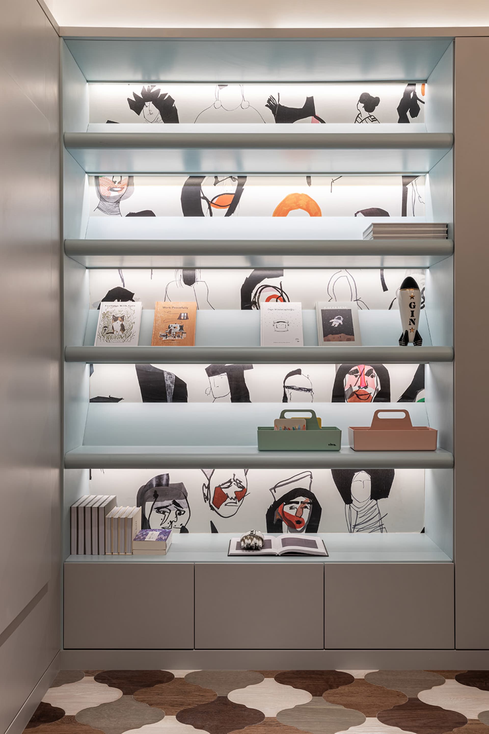 A modern interior design featuring a backlit bookshelf displaying books, storage boxes, and decorative items.