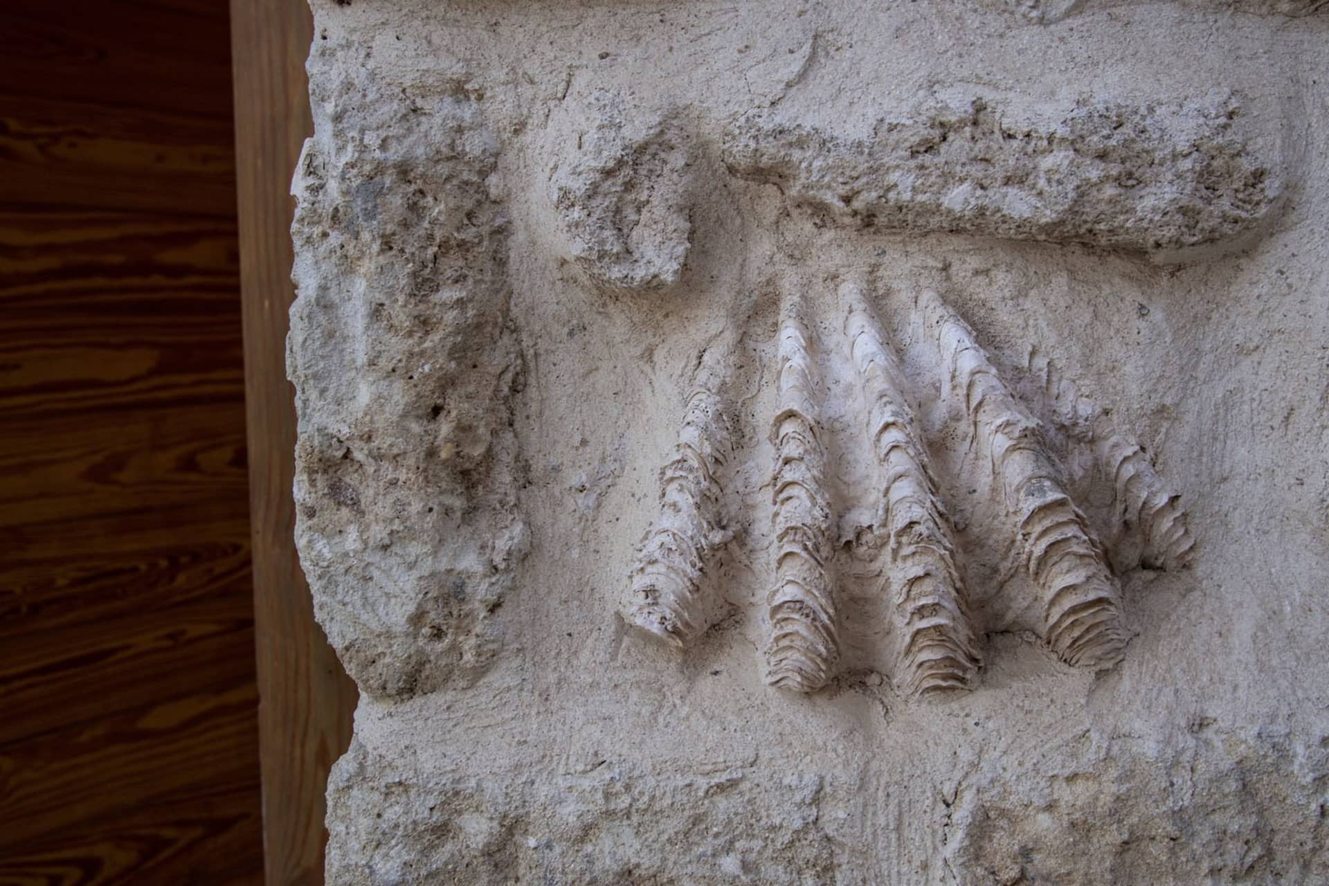 Ancient stone mural depicting a handprint with three fingers.