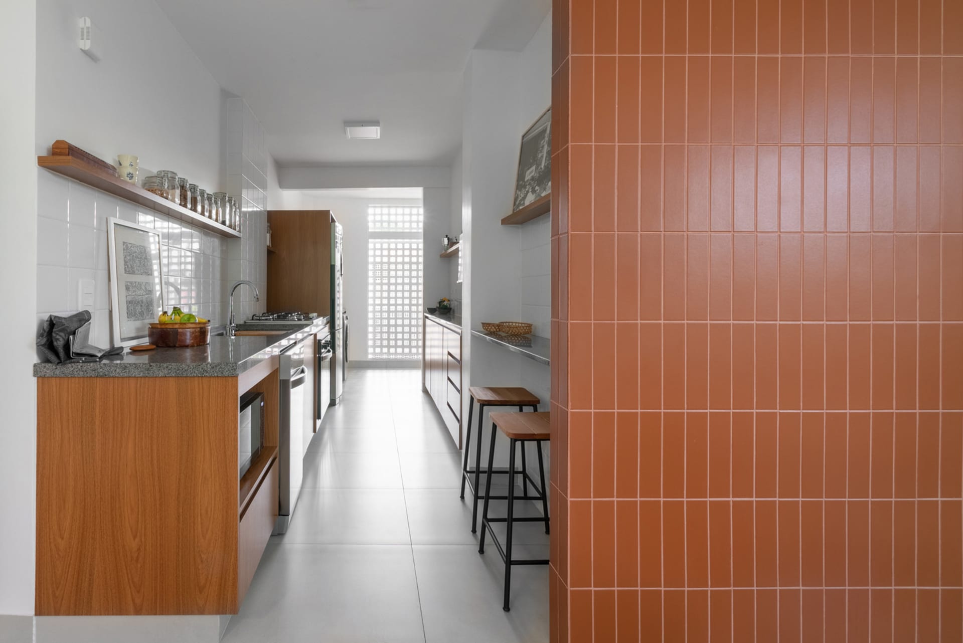 Modern minimalist kitchen with white and wood finishes and terracotta tile backsplash.