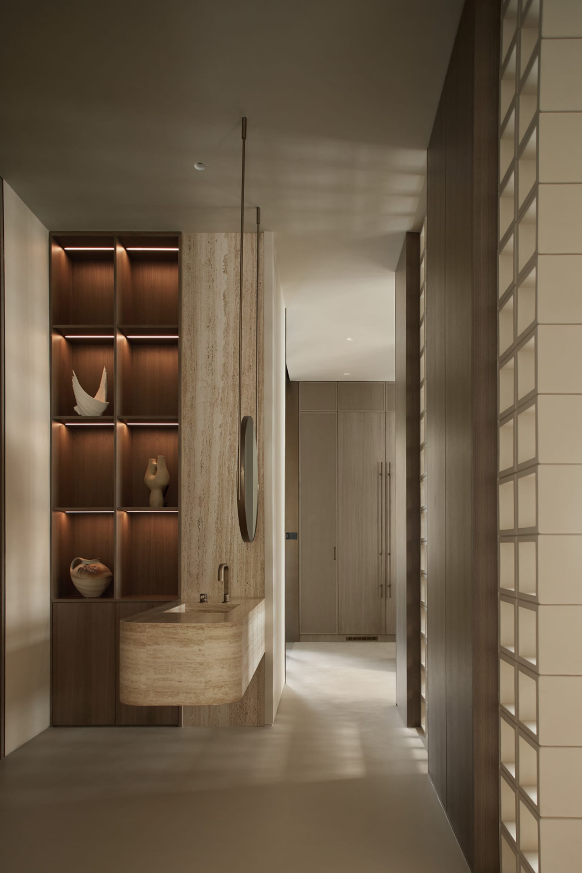 Modern bathroom featuring a wooden vanity with a sink, illuminated shelves, and a spacious layout.