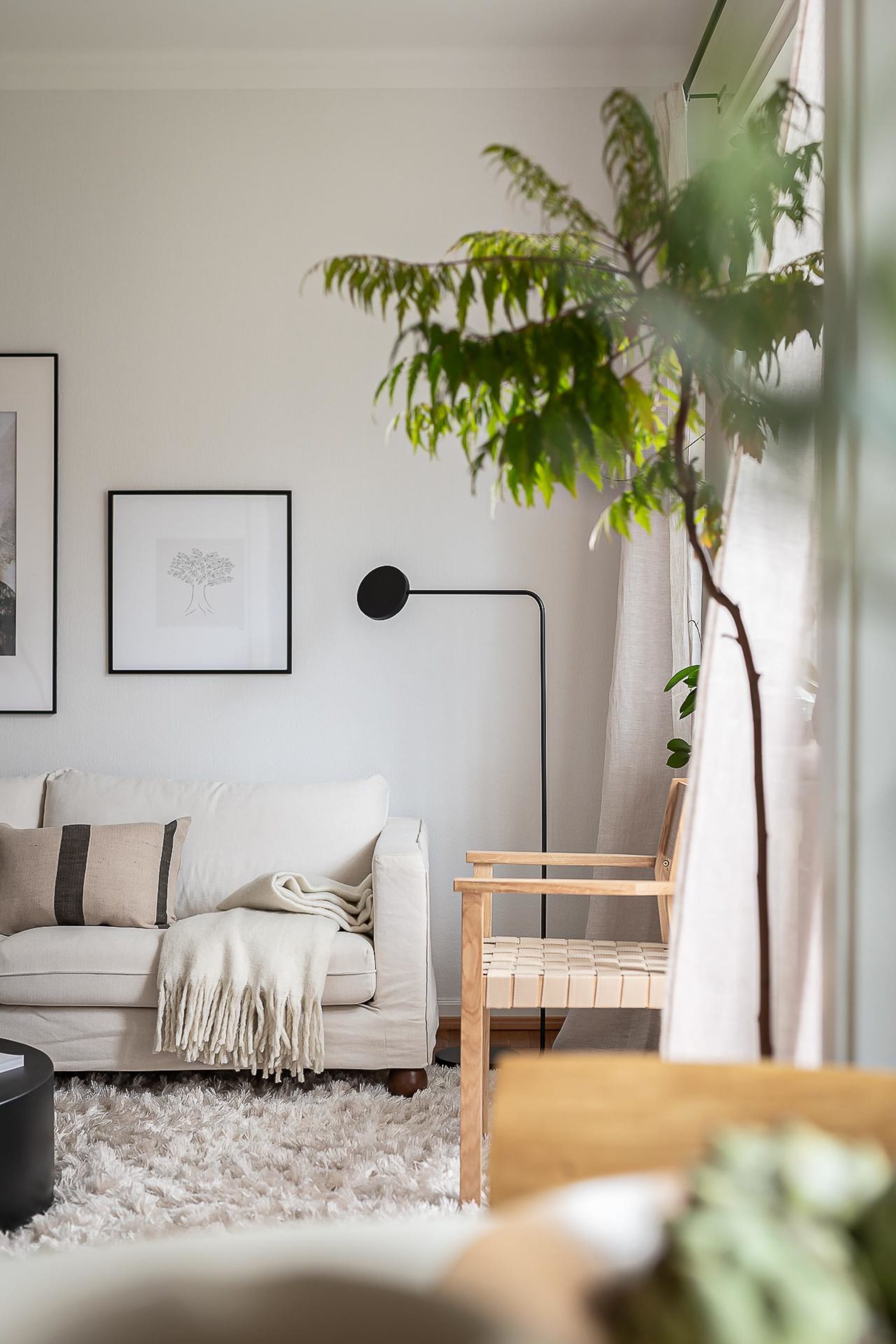 A minimalist living space featuring a couch, wall art, and a wooden bench.