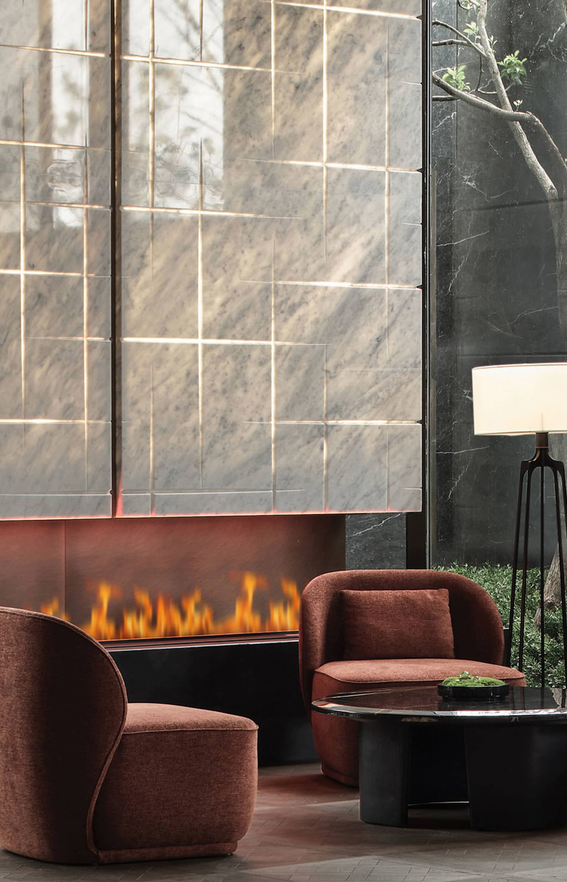 A modern living room with a marble fireplace and brown upholstered chairs.