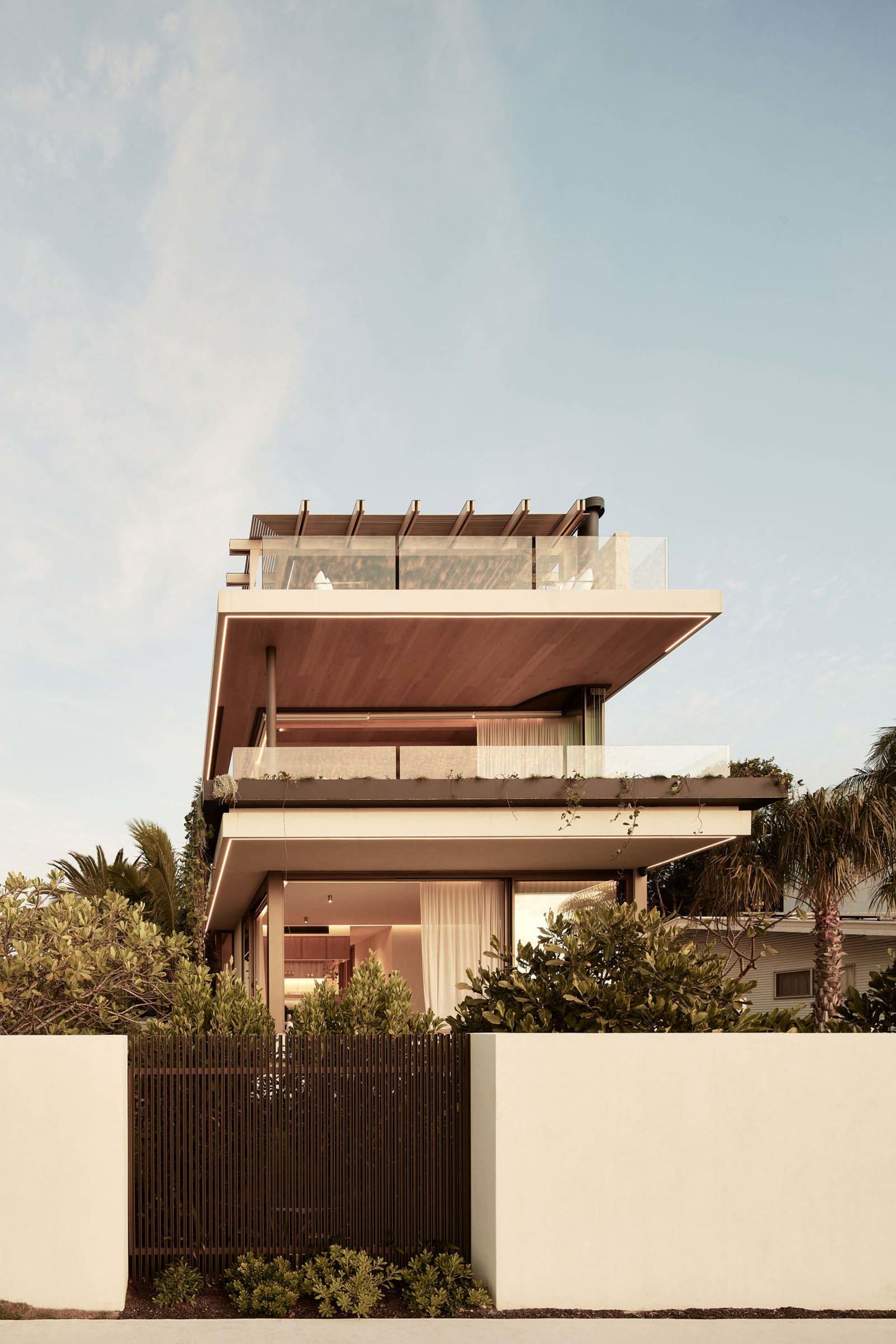 Modern house featuring large glass windows and concrete walls.