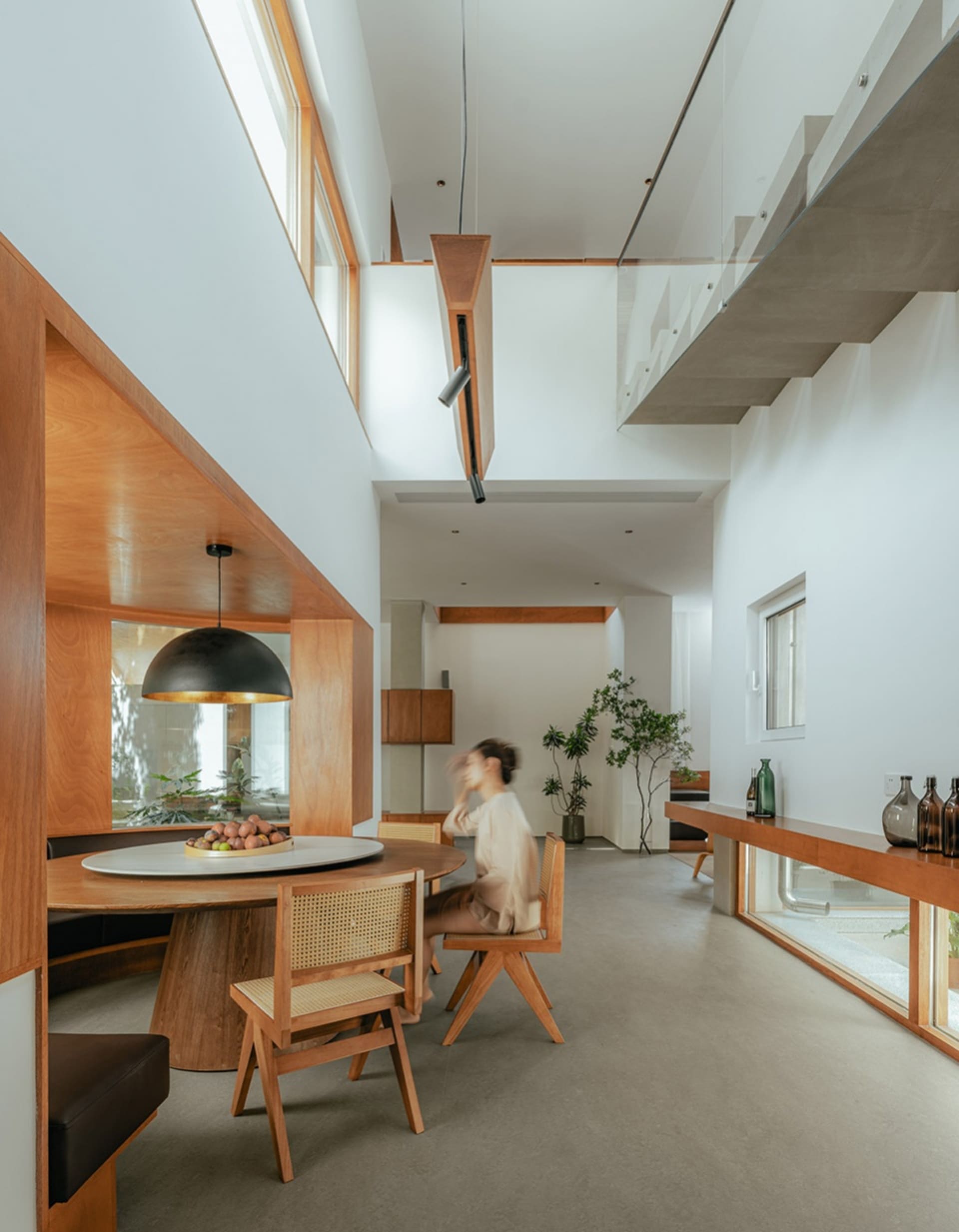 A modern living room featuring wood, concrete, and glass materials and furniture.