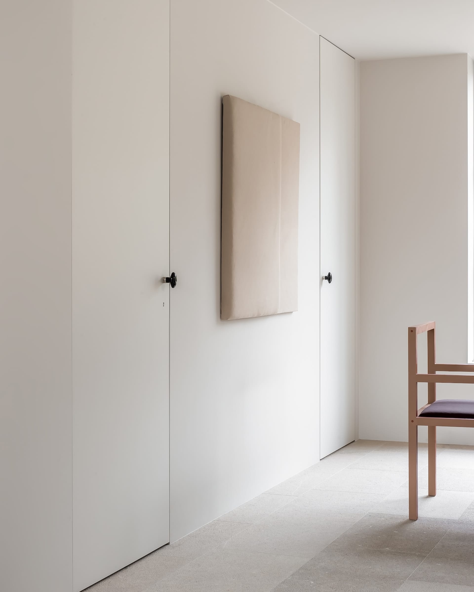 A minimalist interior space featuring concrete walls and furniture.