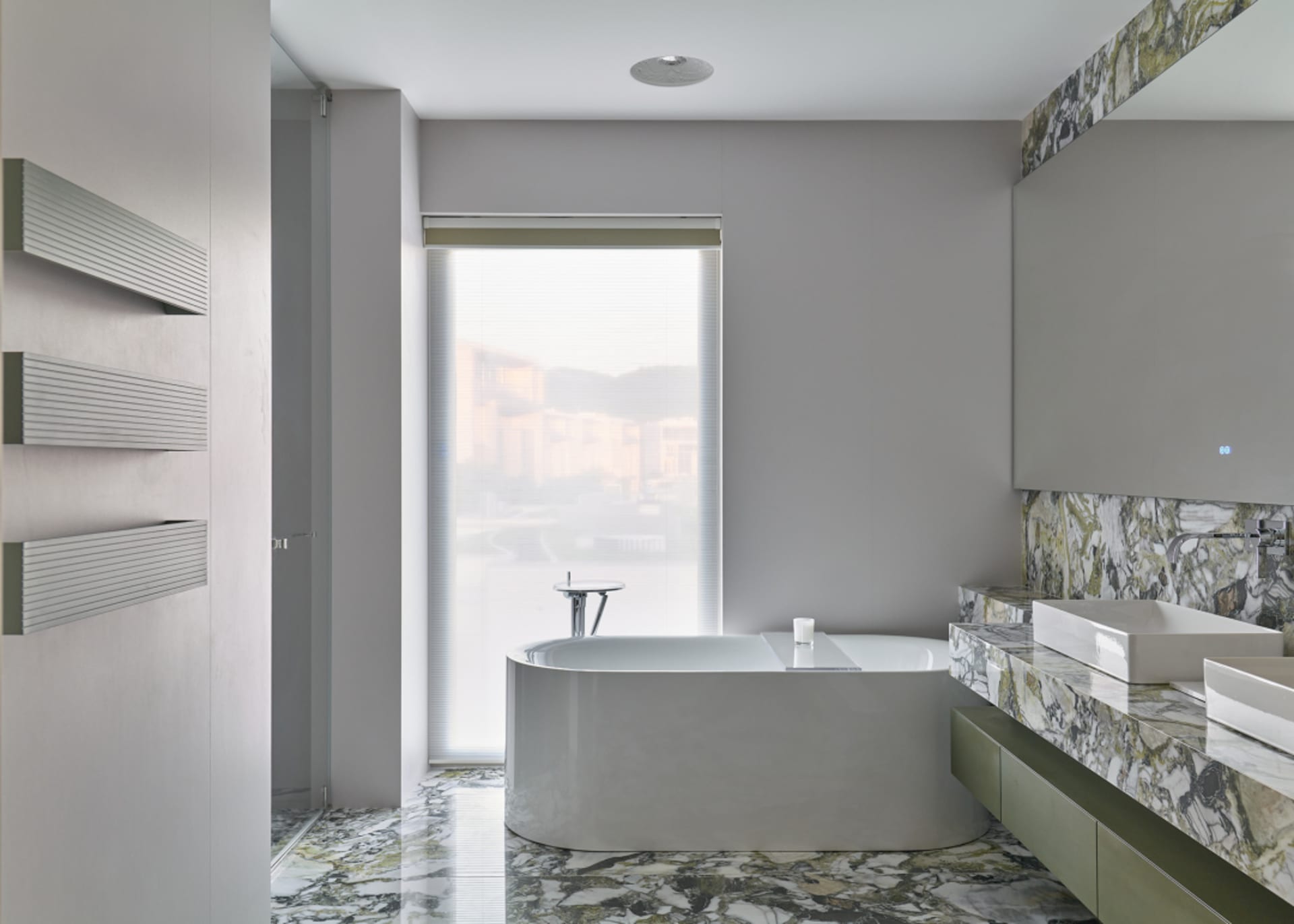 Modern industrial bathroom featuring a white freestanding tub with a marble floor and countertop.