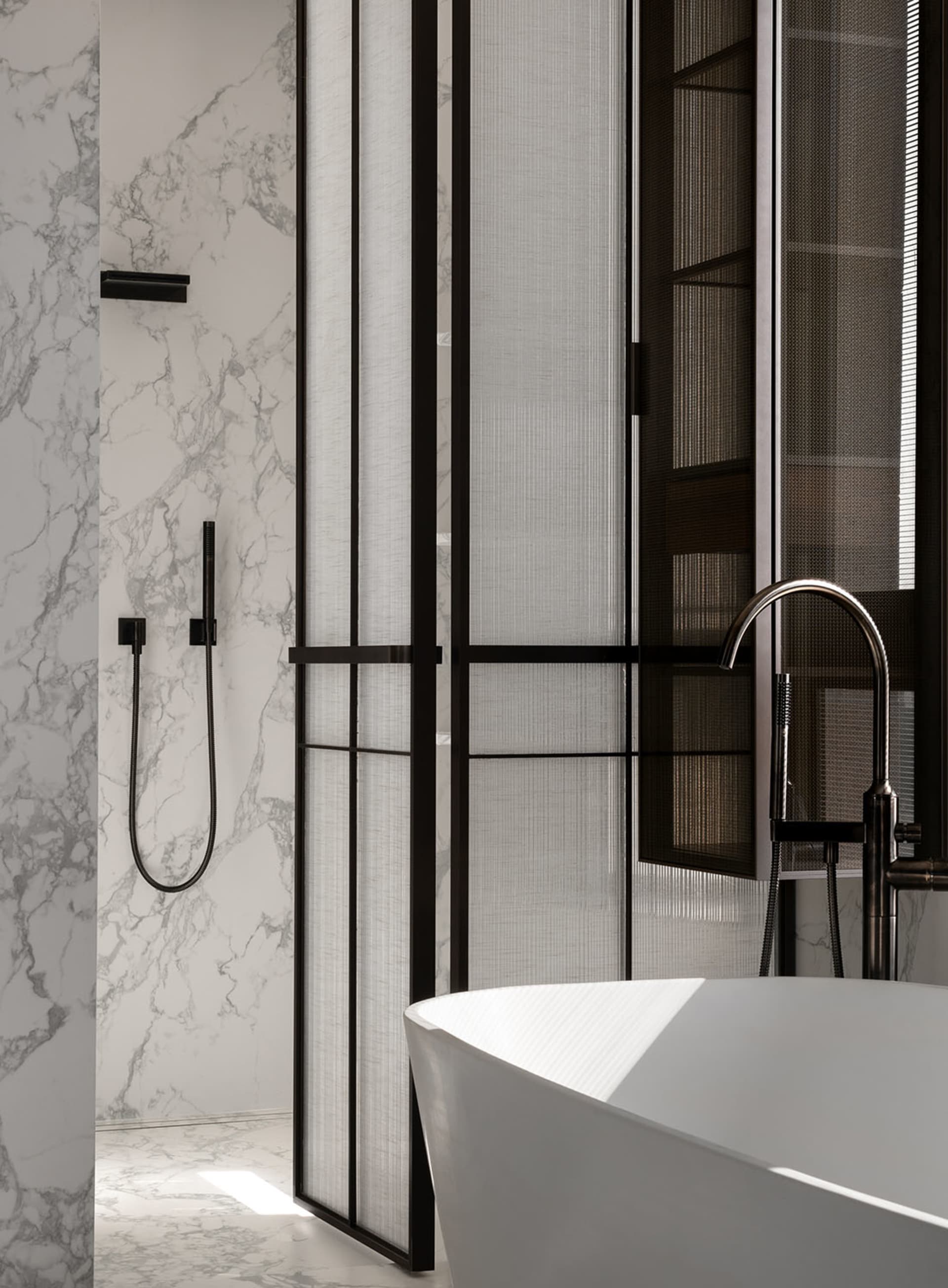 Modern bathroom featuring a freestanding bathtub and marble walls and floor.