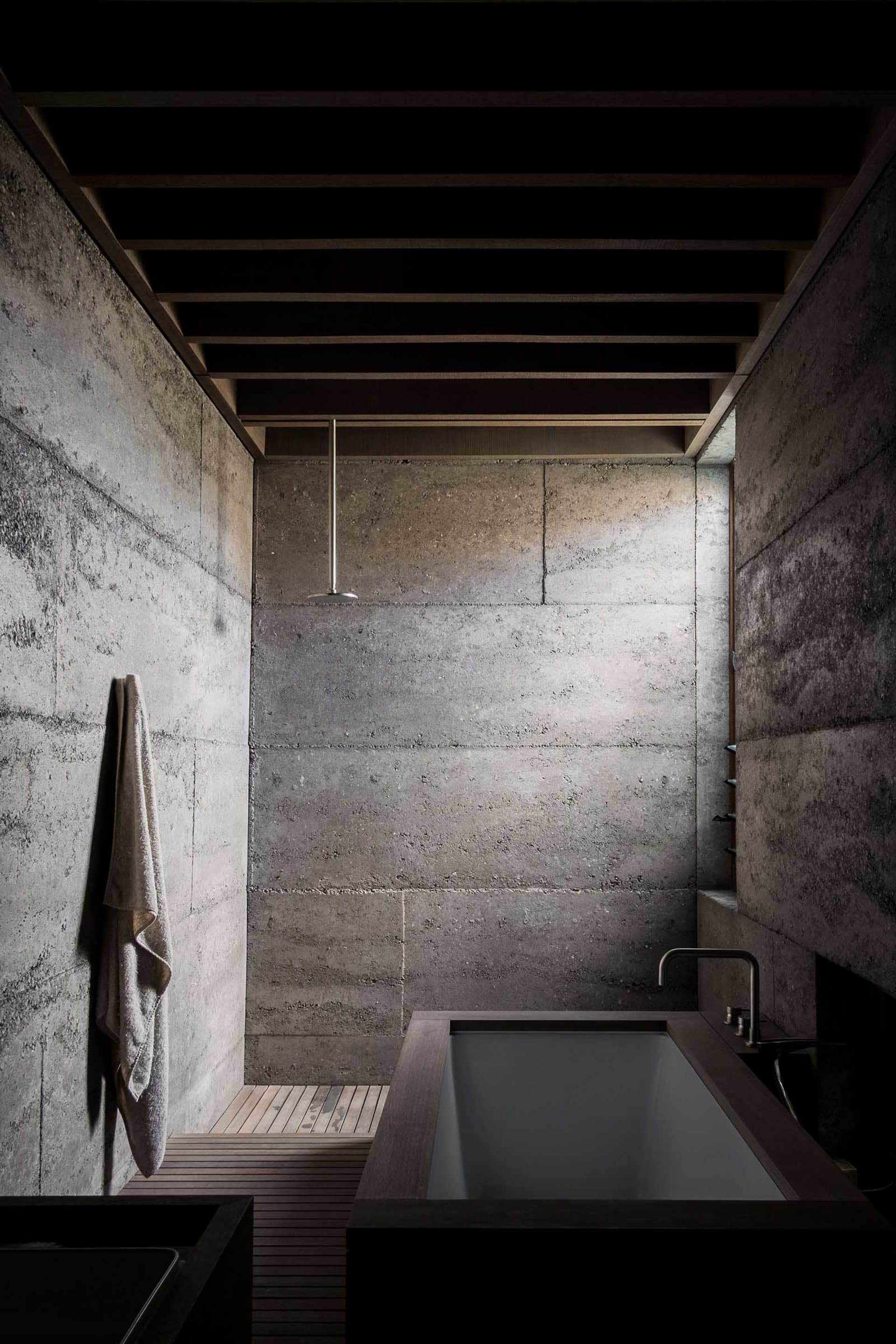 Concrete bathroom with industrial design elements, including exposed beams and minimalist fixtures.