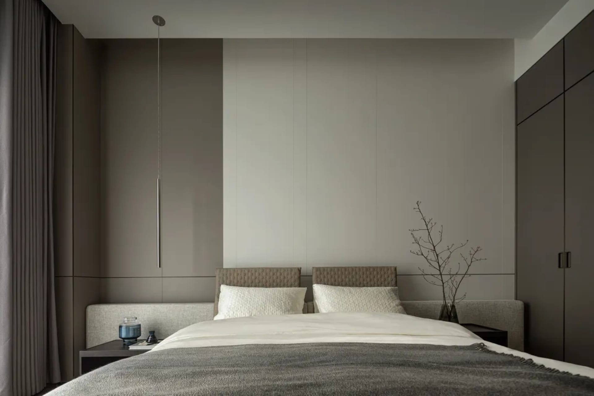 Modern, minimalist bedroom featuring a textured headboard and bedding.