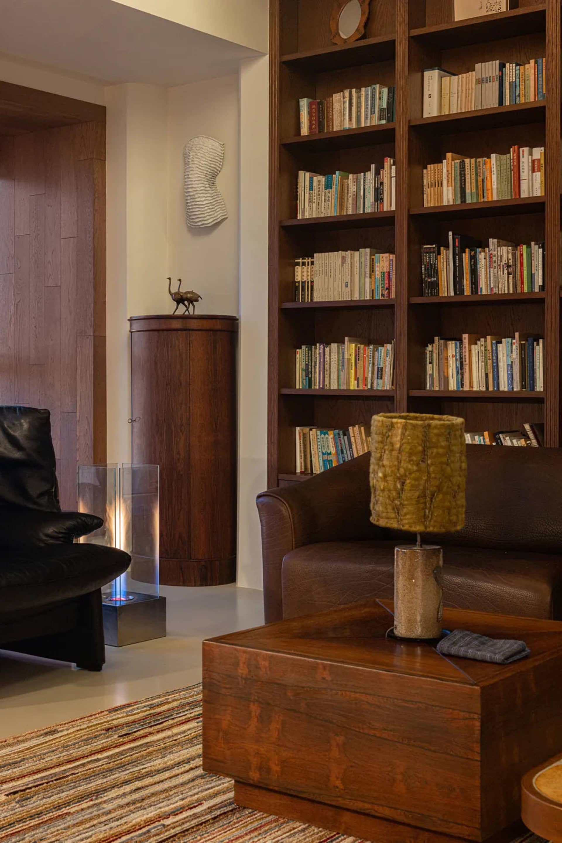 Modern industrial living room with wood, leather, and glass elements.