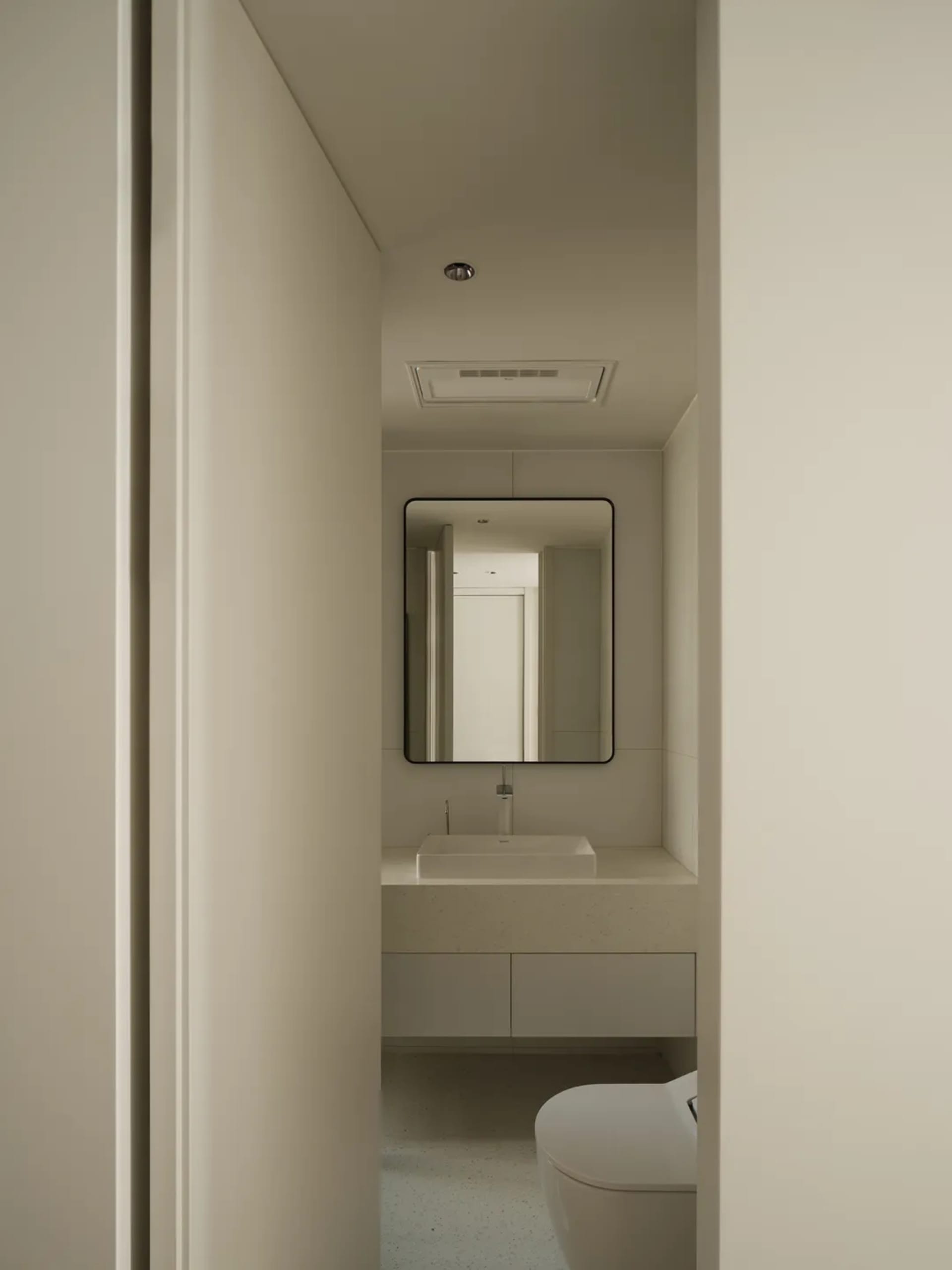 White concrete and terrazzo flooring in a minimalist bathroom
