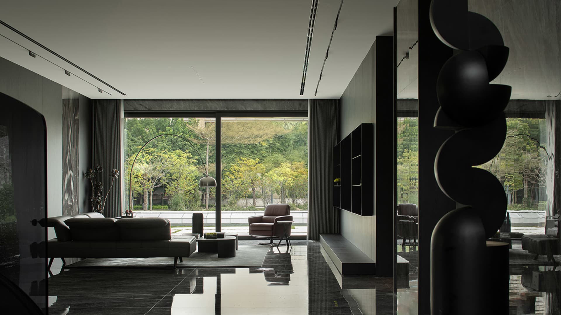 Modern interior design of a living room featuring sleek black furniture and glass floors.