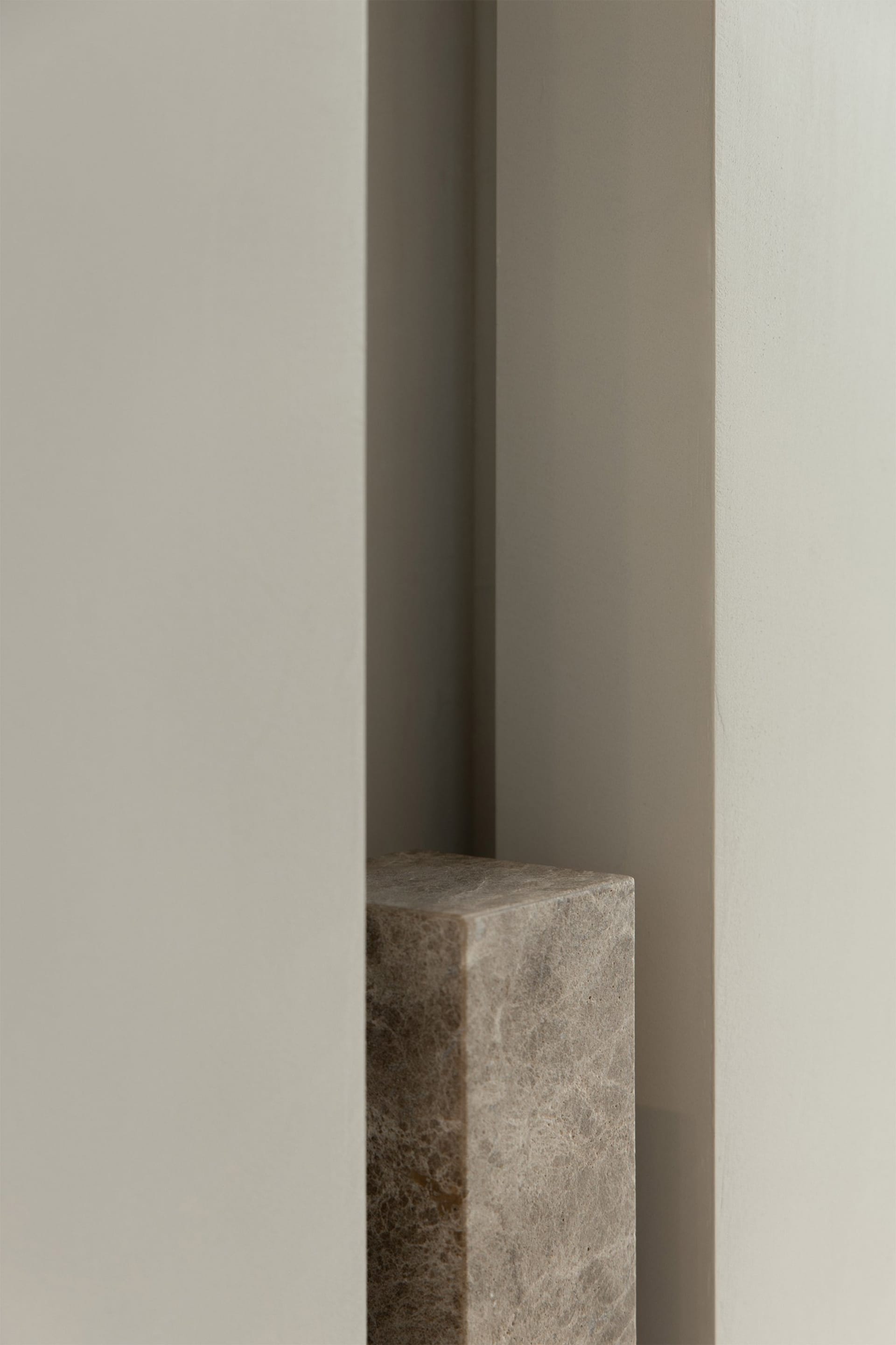 Close-up image of a modern interior concrete column against a plain wall background.
