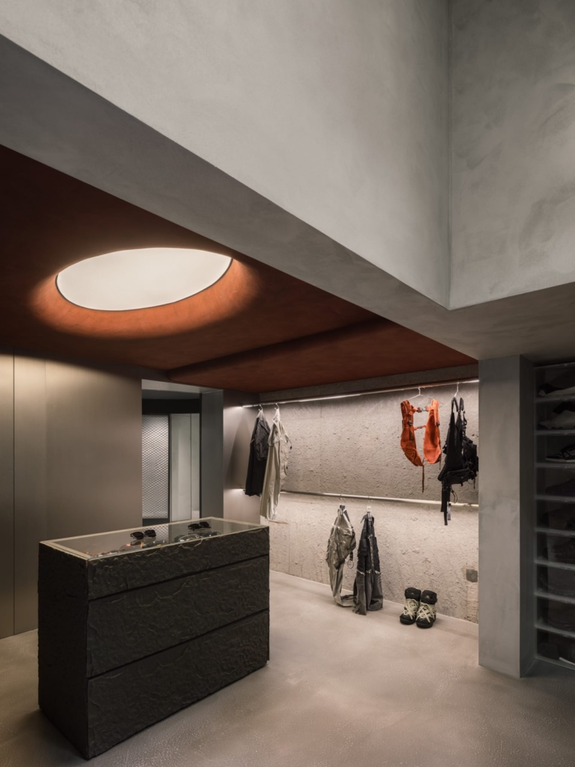 Modern industrial clothing retail store interior with concrete walls and minimalist design.